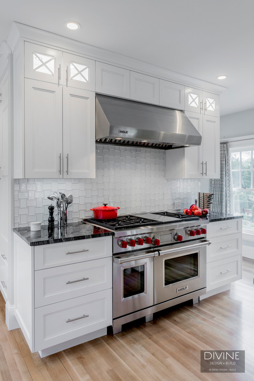  Floral sphere pendant lights with glass tiled back splash. Wolf appliances, stainless steel farmhouse sink. Granite countertops, and white shaker style cabinets.