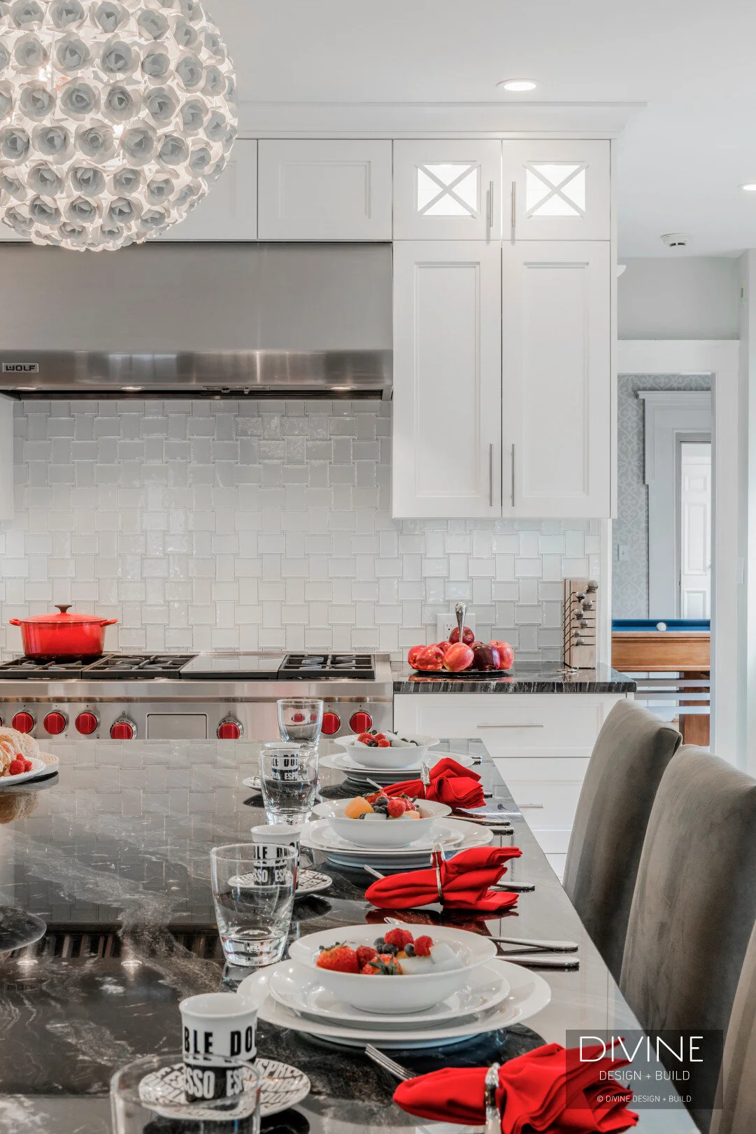  Floral sphere pendant lights with glass tiled back splash. Wolf appliances, stainless steel farmhouse sink. Granite countertops, and white shaker style cabinets.