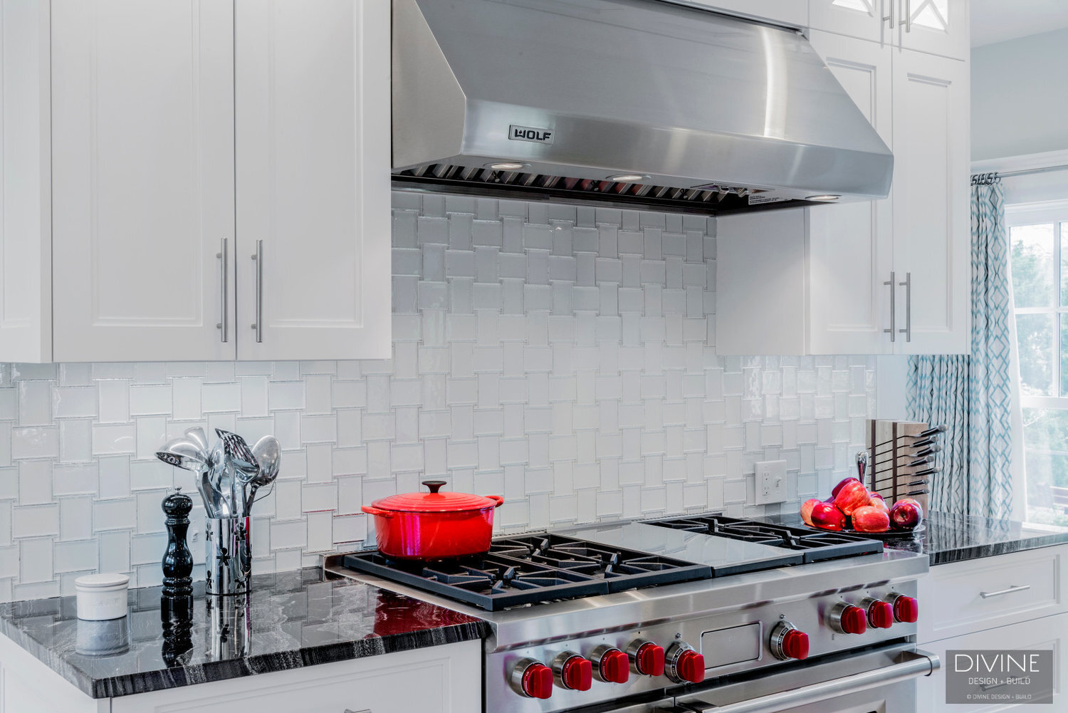  Floral sphere pendant lights with glass tiled back splash. Wolf appliances, stainless steel farmhouse sink. Granite countertops, and white shaker style cabinets.