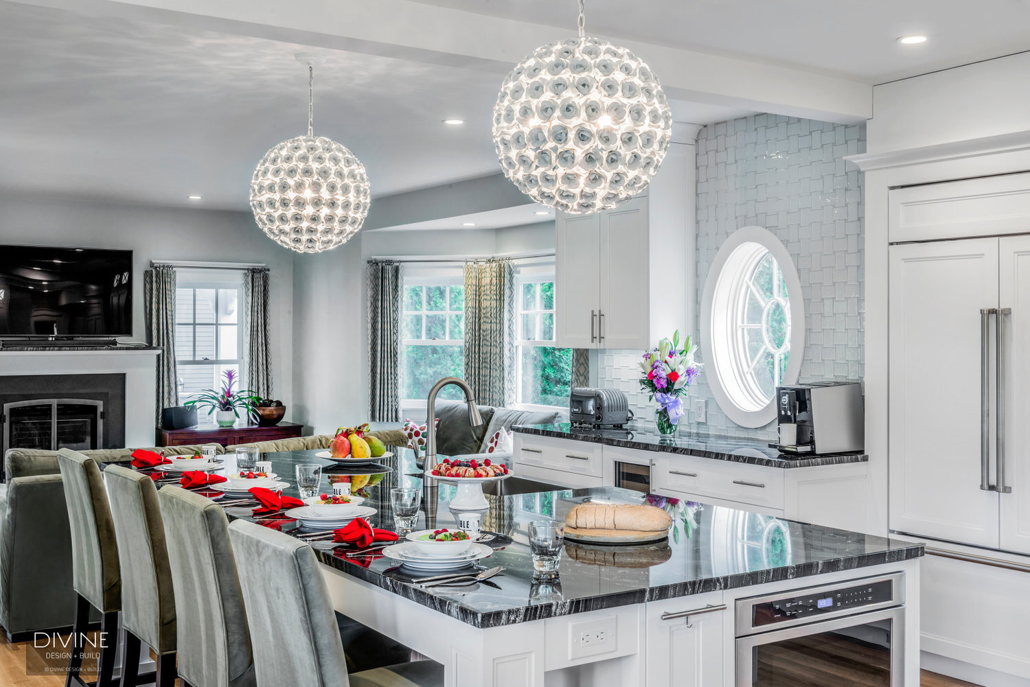  Floral sphere pendant lights with glass tiled back splash. Wolf appliances, stainless steel farmhouse sink. Granite countertops, and white shaker style cabinets.