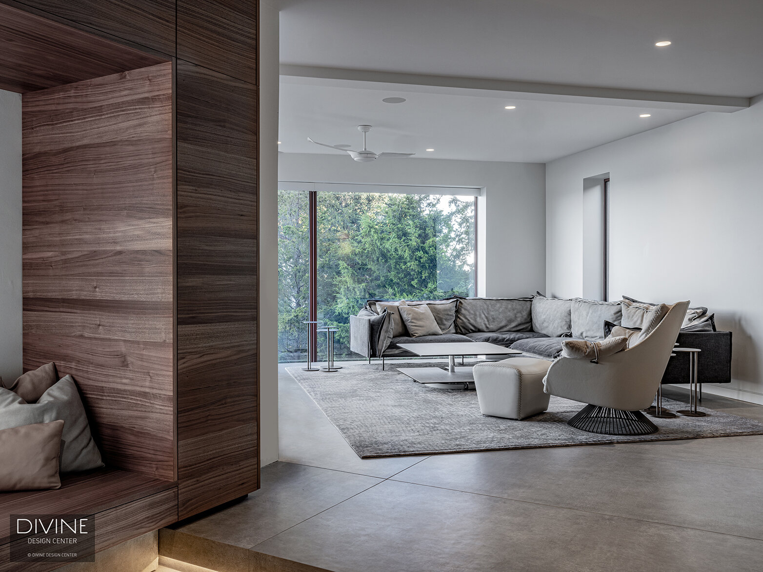  A niche seating area in walnut in the forefront in the step down of a concrete step with architectural lighting below - in the background is a large living area in cool, grey tones with Leolux and Rolf Benz furniture of a similar modern style. A lar