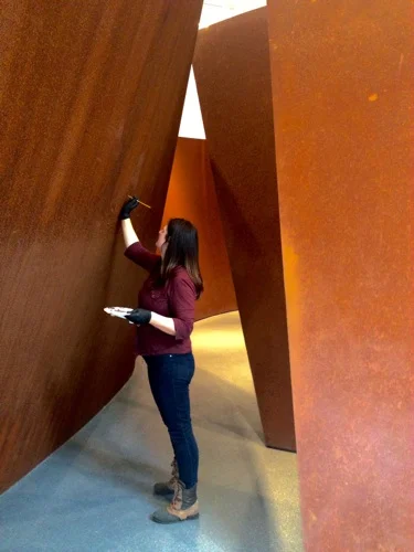 Rowan Geiger treating a Richard Serra sculpture