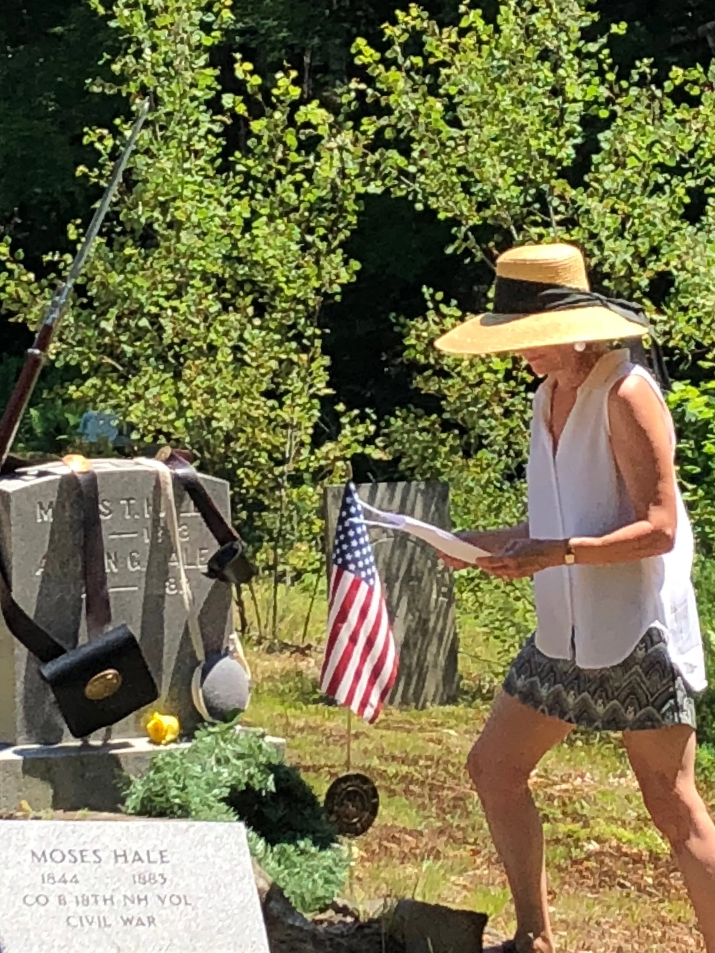 Orange Selectboard Chair Dorothy Behlen Heinrichs lays a flag on the French Cemetery grave of a Civil War Veteran.