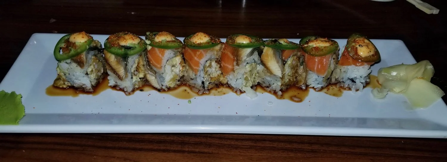 The Tsunami Roll- a spicy soft shell crab roll topped with salmon, eel and jalapeño.