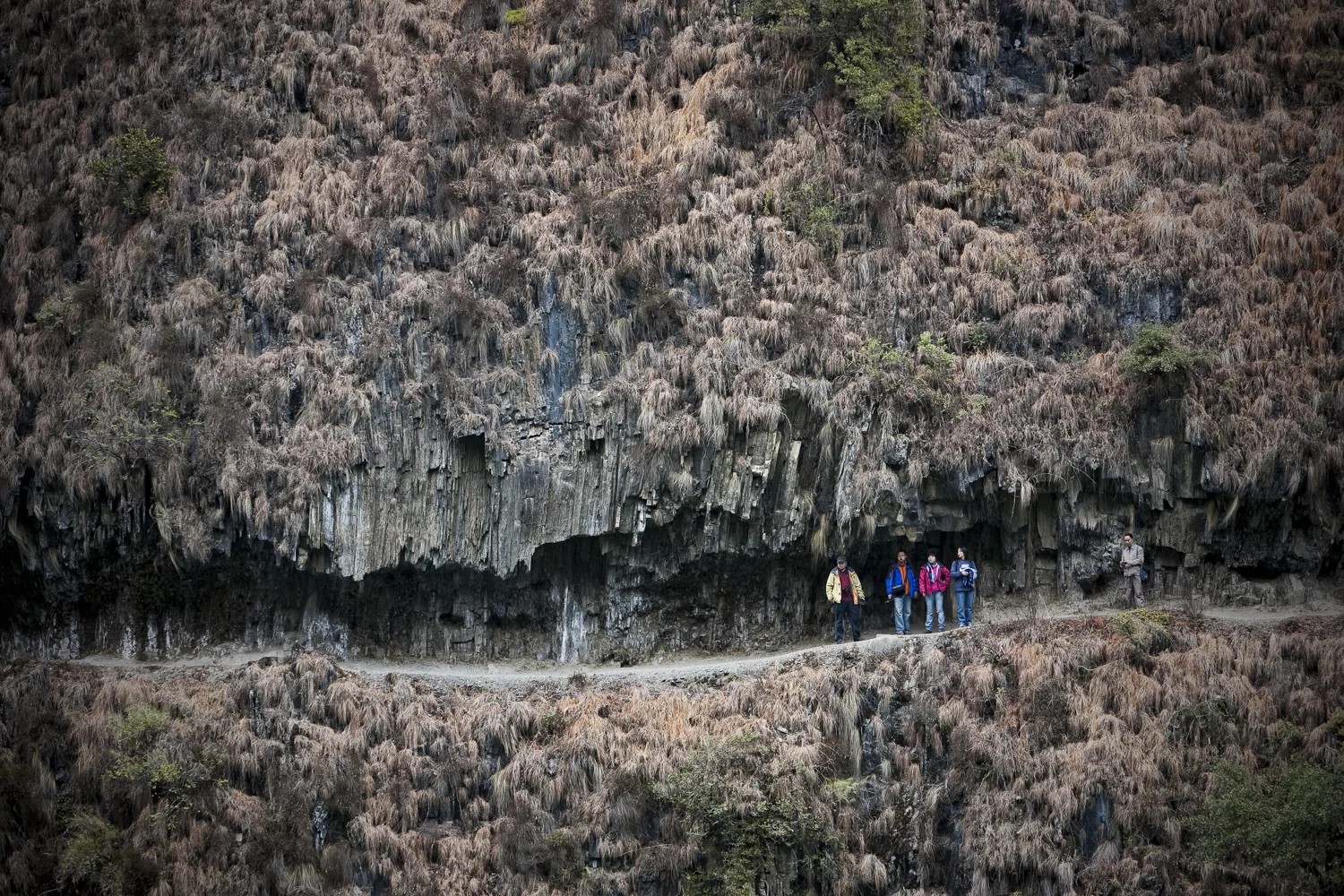 Wuli, Yunnan. The path to Wuli is carved into a mountainside along the Nu River. These tourists have come from Shanghai during their Chinese New Year holiday. As opposed to most of the minority villages in the area who have converted to Christianity Wuli is still a Tibetan Buddhist village. 