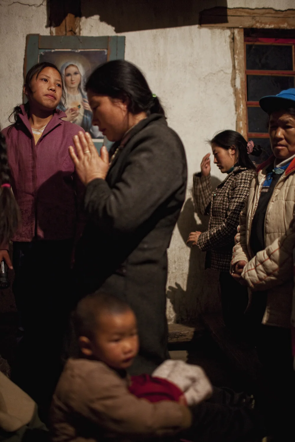 Qiunatong Village, Yunnan. Most of the minority groups converted to Christianity a hundred years ago when missionaries crossed over from Burma. Villagers gather for a late night mass on New Year's Eve. 