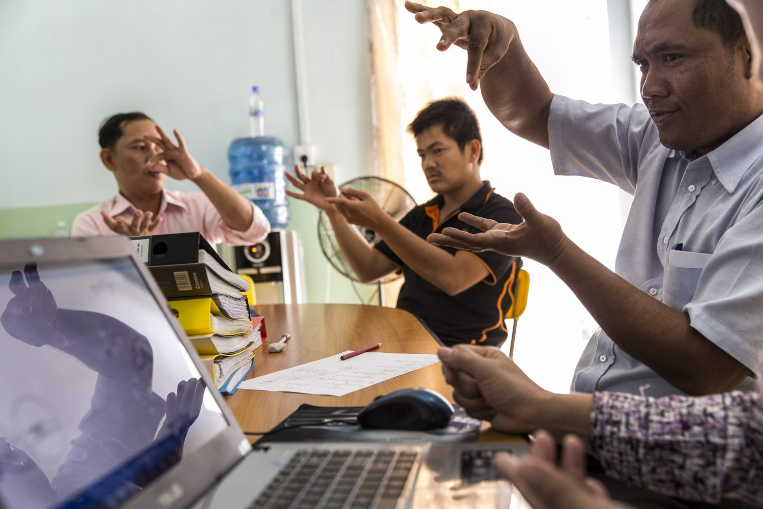  Teachers, translators, linguists from DDP and Krousar Thmey working to create Cambodian Sign Language.. On the right is Sam Ath Heang  who has worked with DDP since its founding and is responible for drawing the pictures and gestures that will later
