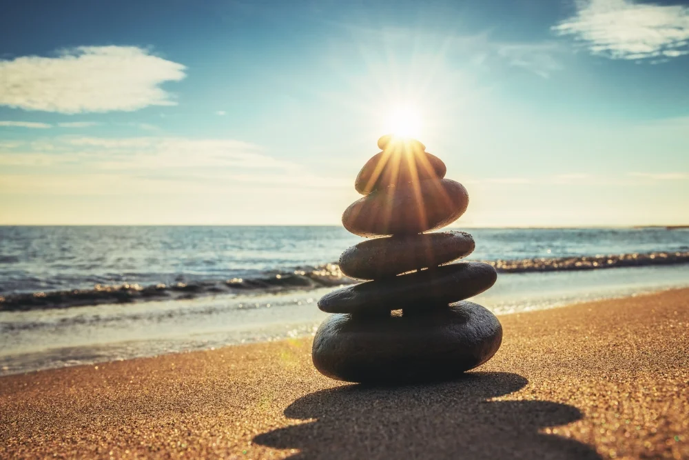 Sunrise on Stones balanced in stack on beach.jpg
