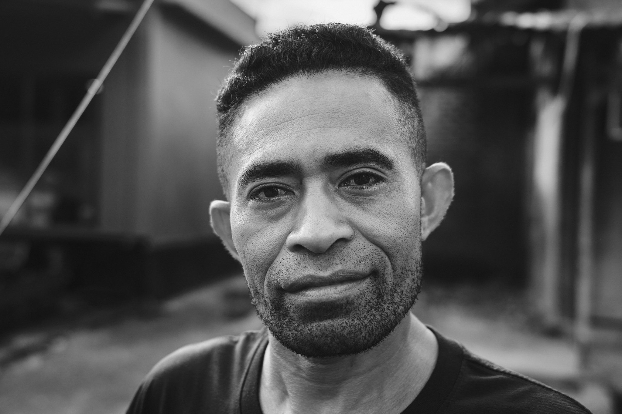 A black-and-white portrait of a local man looking directly at the camera, his expression calm and grounded. Taken in Alor, Indonesia by travel photographer Lee Starnes.