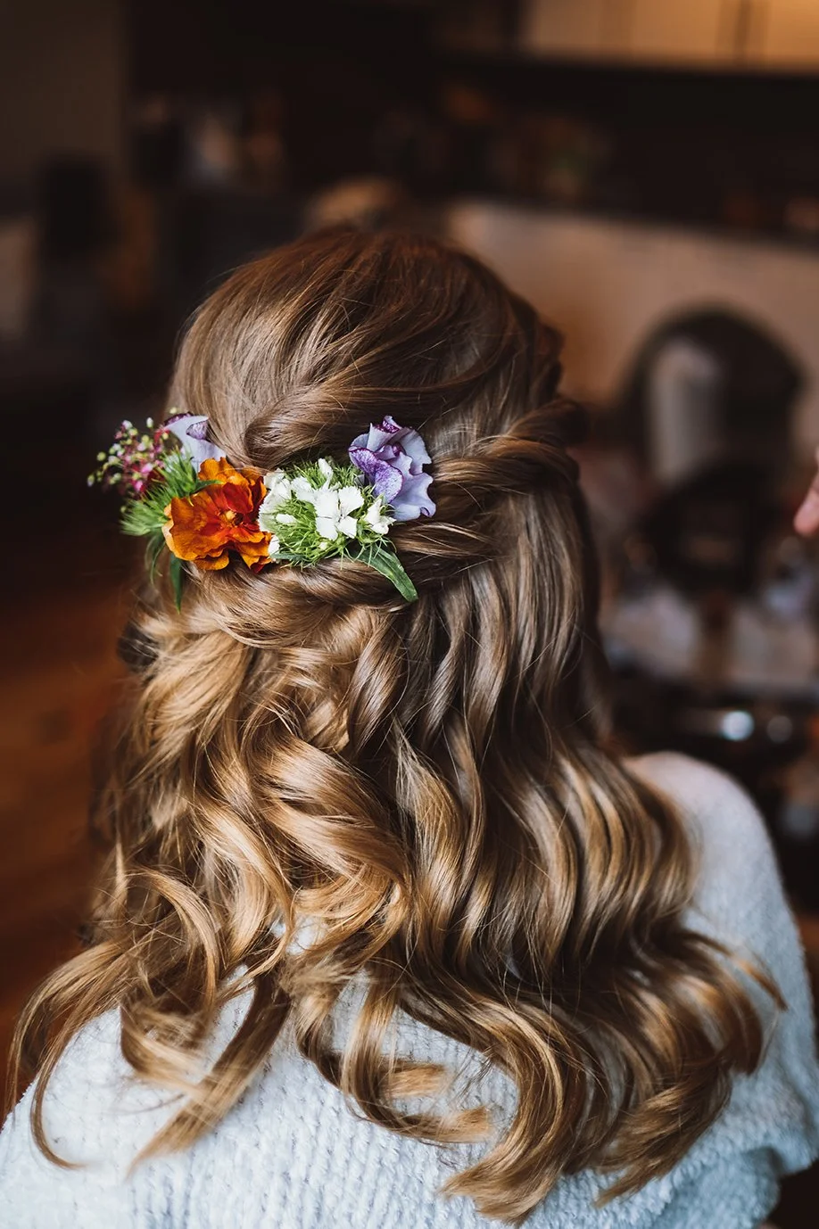 Braut am Hochzeitstag mit Lockiger Frisur und Blumen im Haar Halboffen