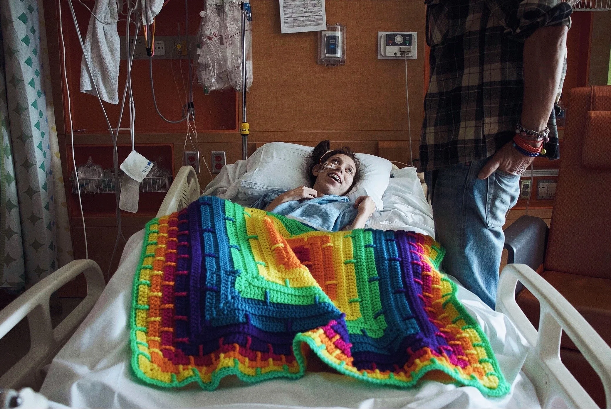 Craig Street (65) stands beside his daughter’s hospital bed. 