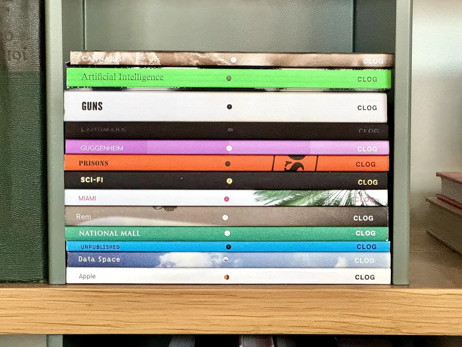 A shelf with colorful books, each labeled with a different title and the word 'CLOG' on the right side.