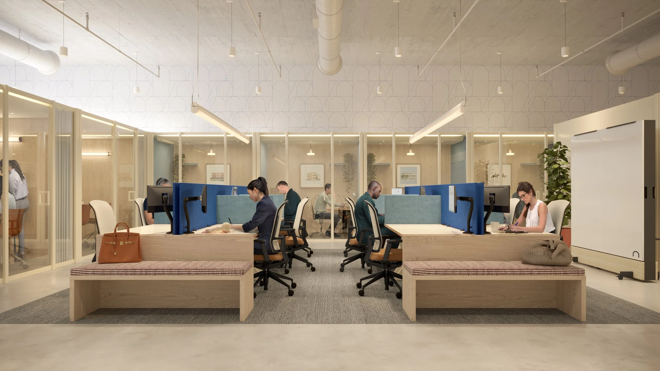 Modern office with employees working at desks separated by dividers, with a seating area at the front, glass-walled meeting rooms on the sides, and ceiling lights.