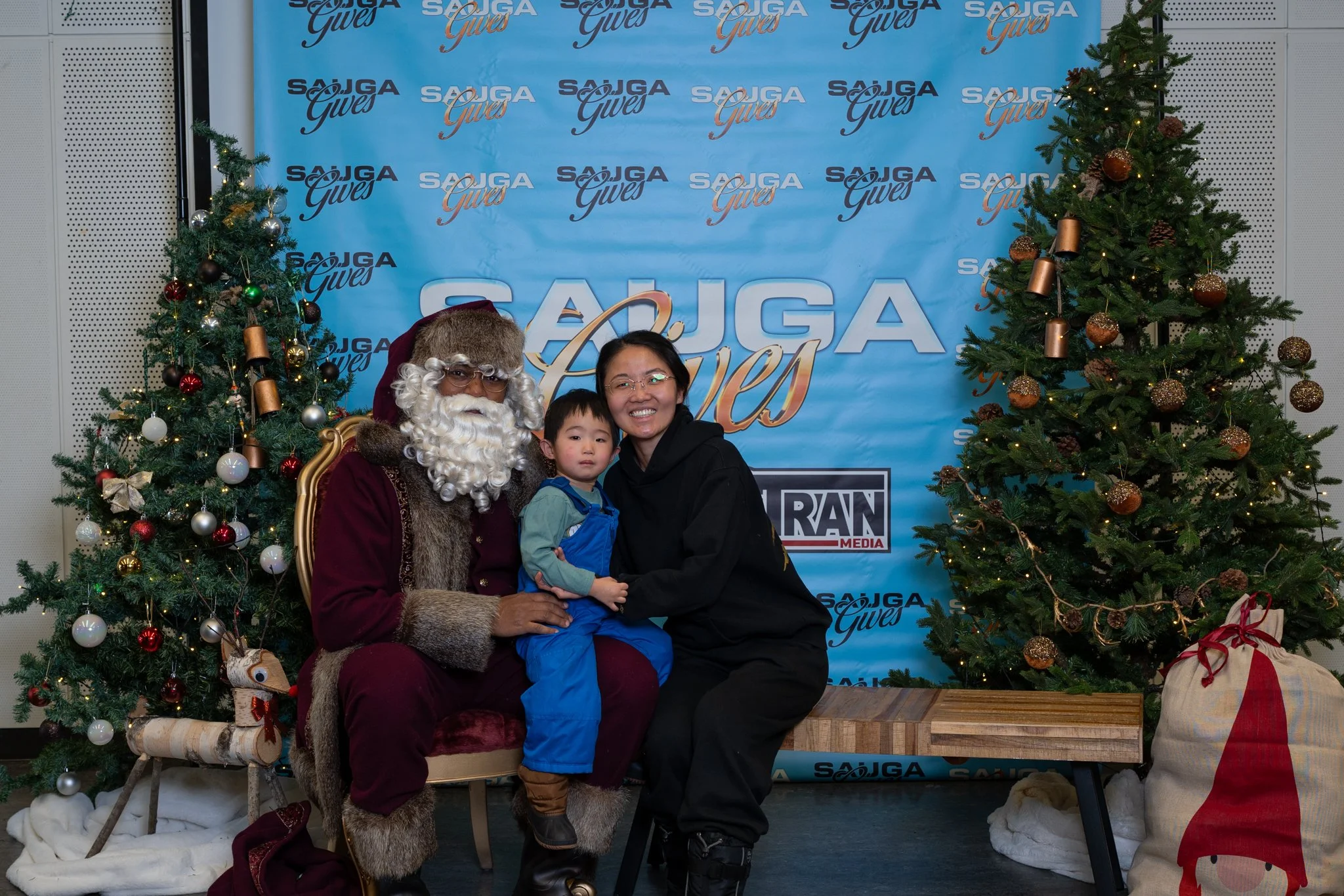 A mother and her small child posing with Santa at the 2025 Sauga Gives holiday event.