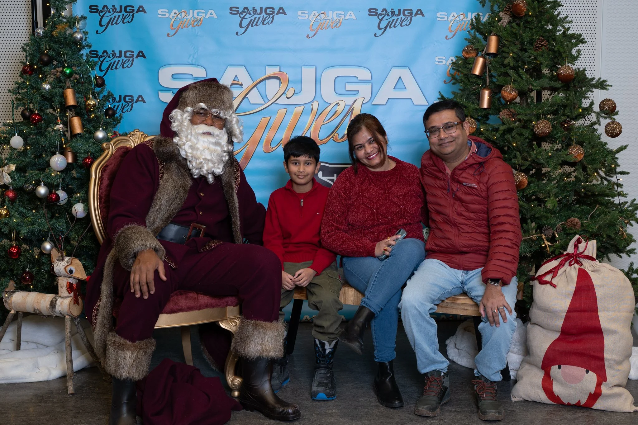 A family of three sitting with Santa at the 2025 Sauga Gives Christmas event.