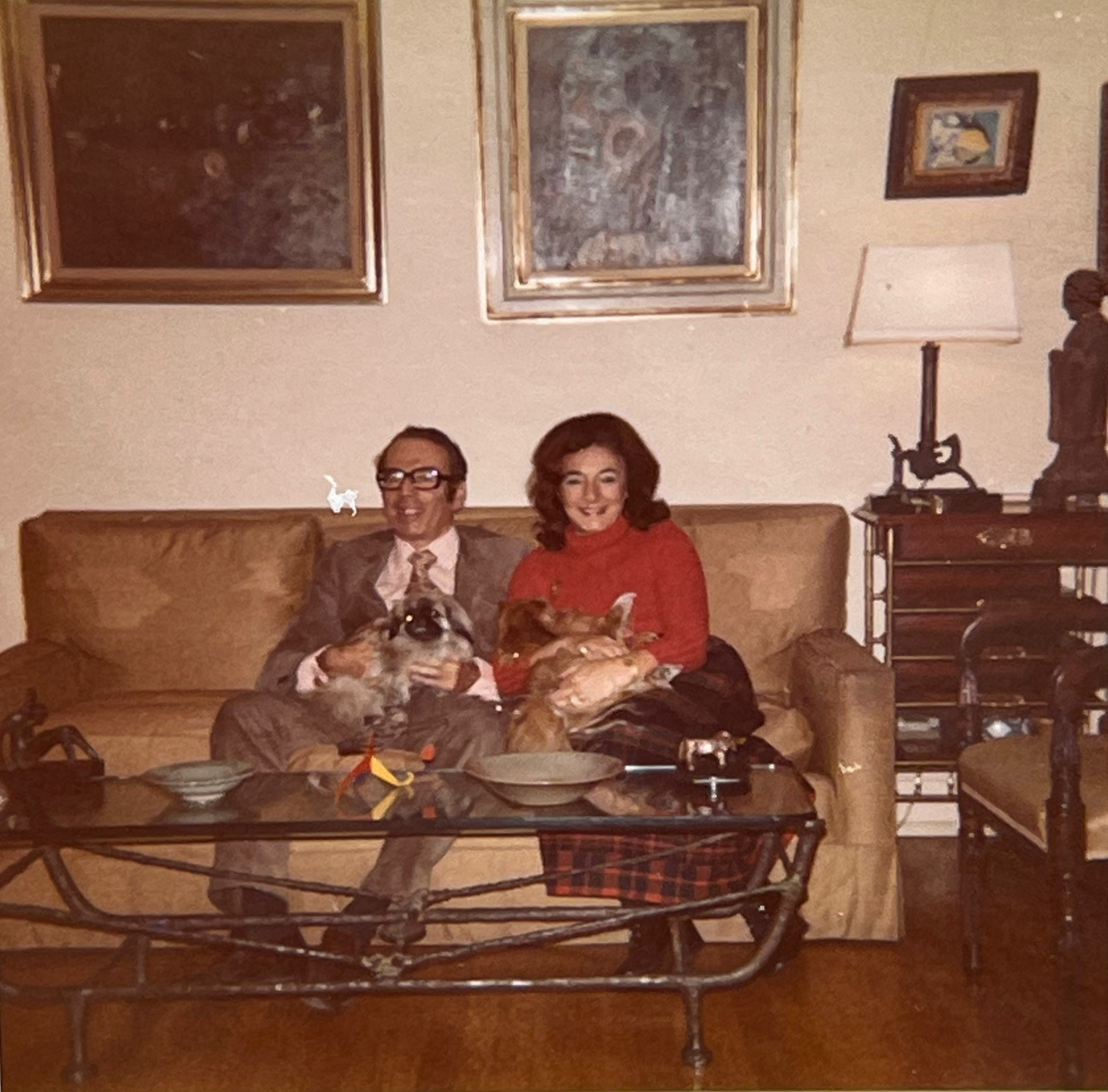 Bob and Rena holding their dogs, Fru Fru and Mimi while sitting in their London house. Notice the Alberto Giacometti table with a Henry Moore and Alexander Calder sculpture.