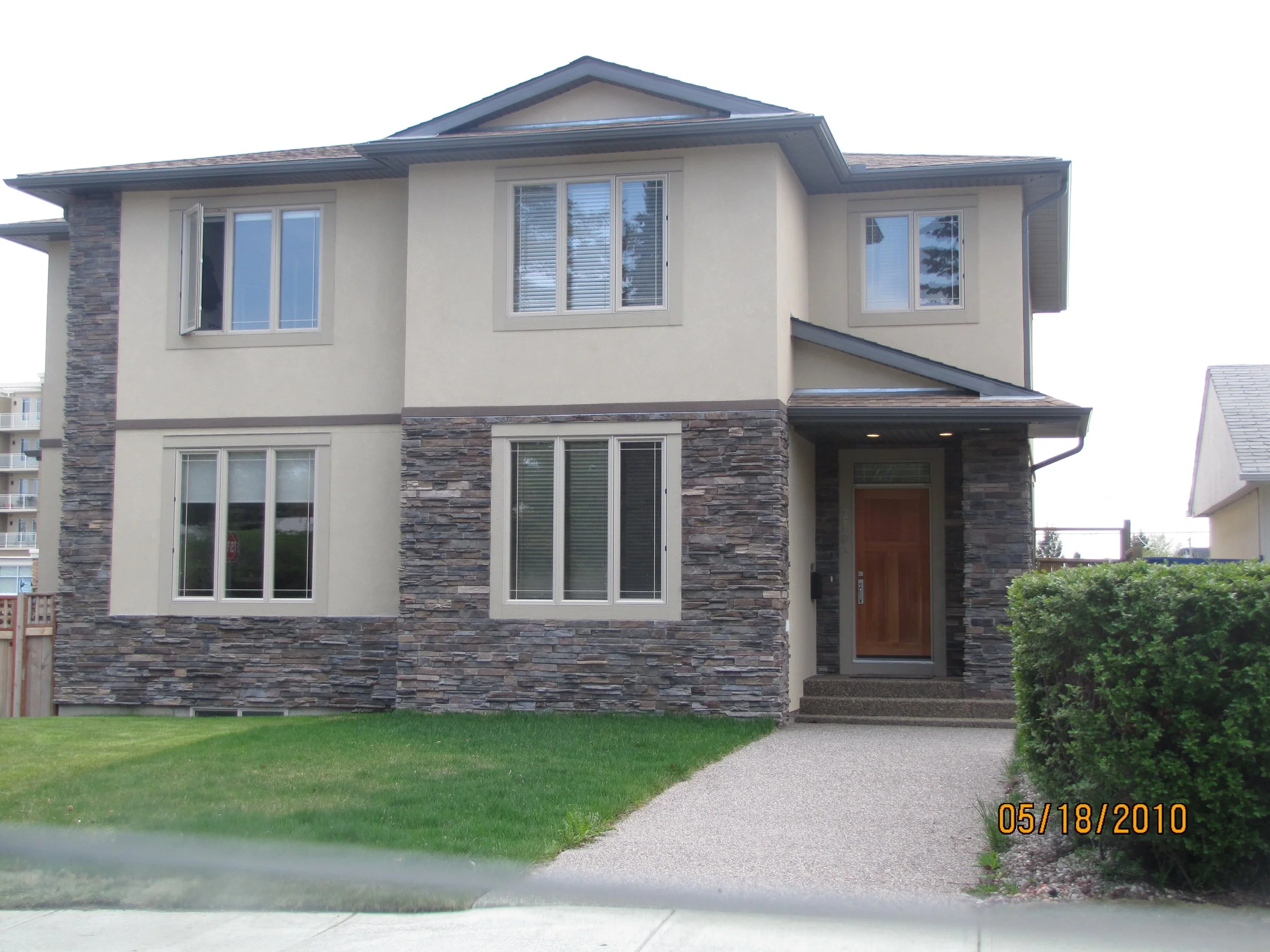Cultured stone installation on Calgary home exterior by Uruk Stucco & Exteriors”