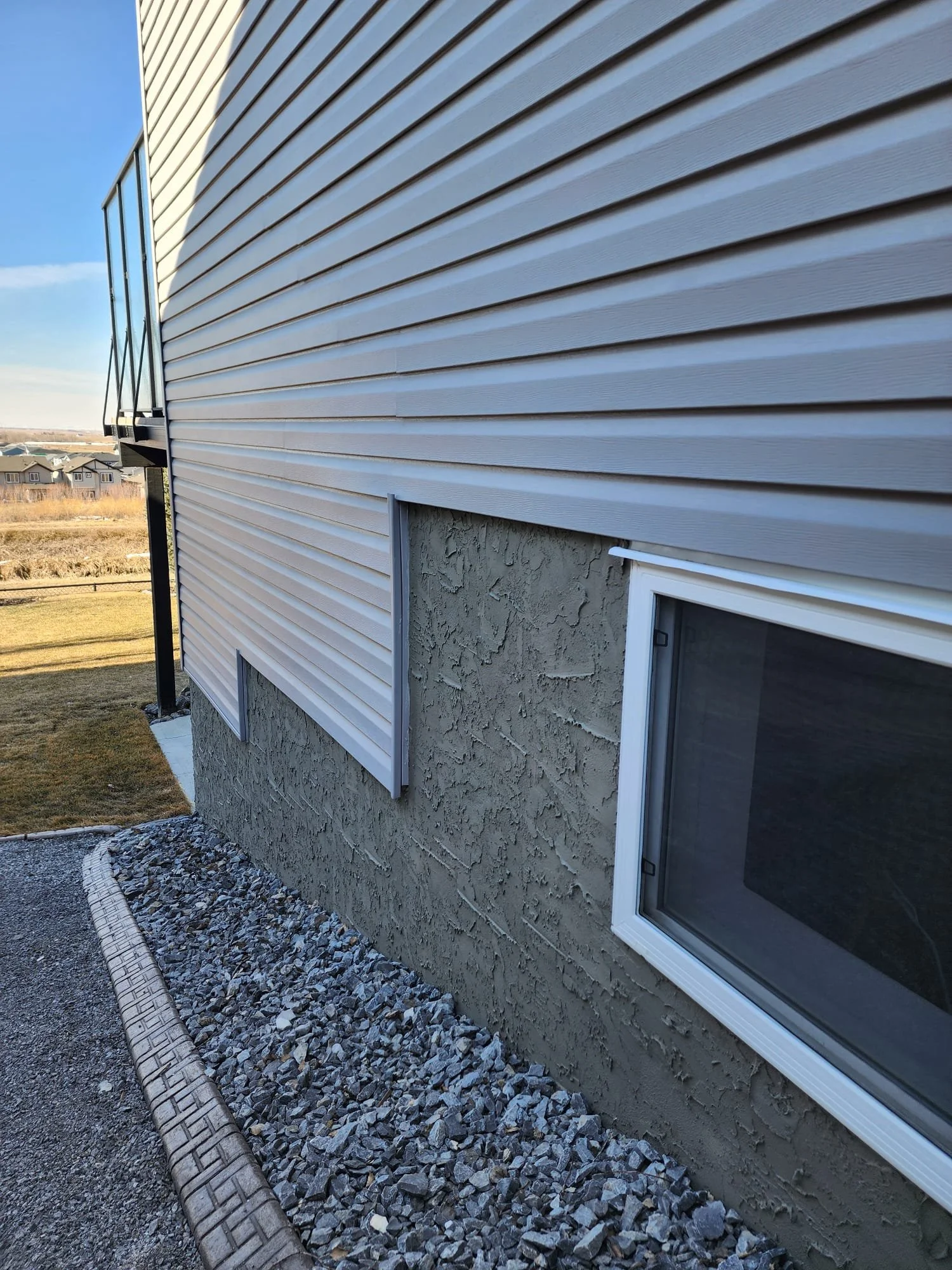 knock down parging below wall siding. uruk stucco ltd