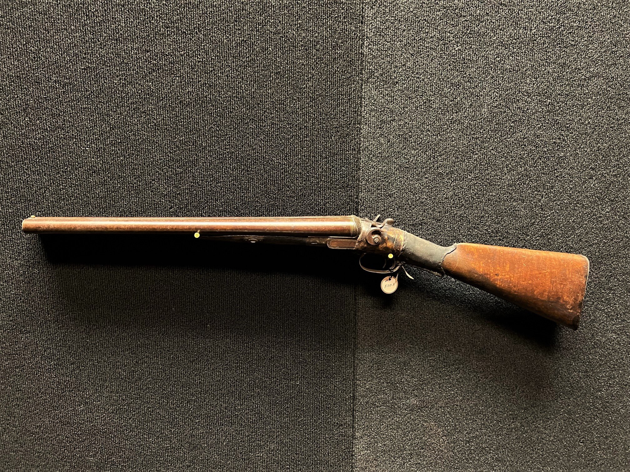 Traditional kentucky rifle and a gunpowder horn on an old, damaged board  Stock Photo