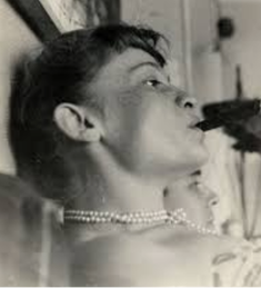 A photo of Eliane Radigue smoking a cigar, taken by her husband at that time, French artist Arman.