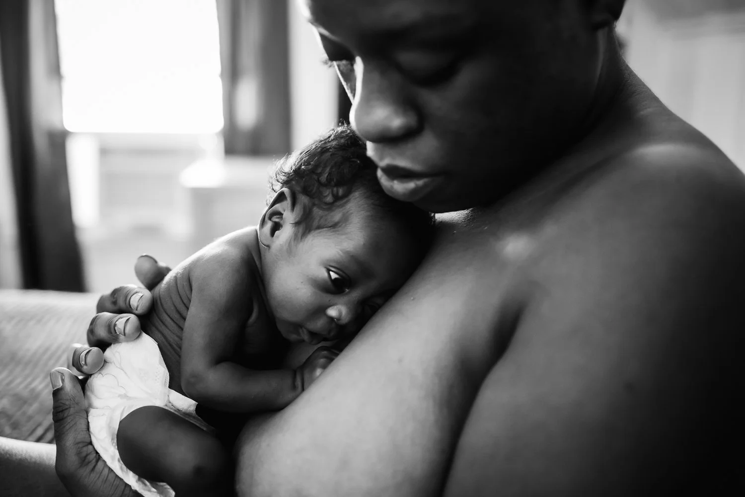 tiny baby snuggled against mom's chest