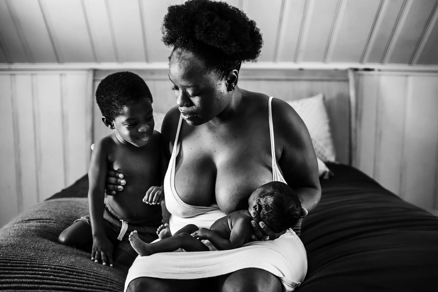 Nursing a preemie baby with big brother smiling