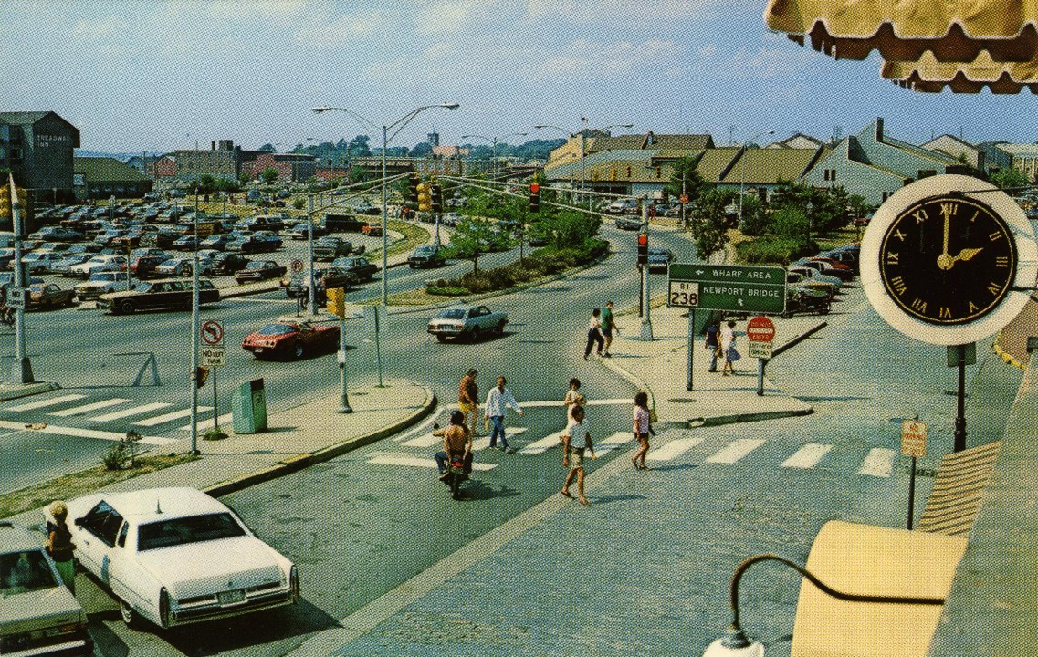 Thames Street at foot of Mill Street looking north. In this photo from the late 1970’s, most everything we see to the left of the clock was “redevelop” land. In the far distance we can see J.T. O’Connell’s lumber yard on Long Wharf (now the Marriott). Note the clock face in this photo. It was visible on the previous slide.