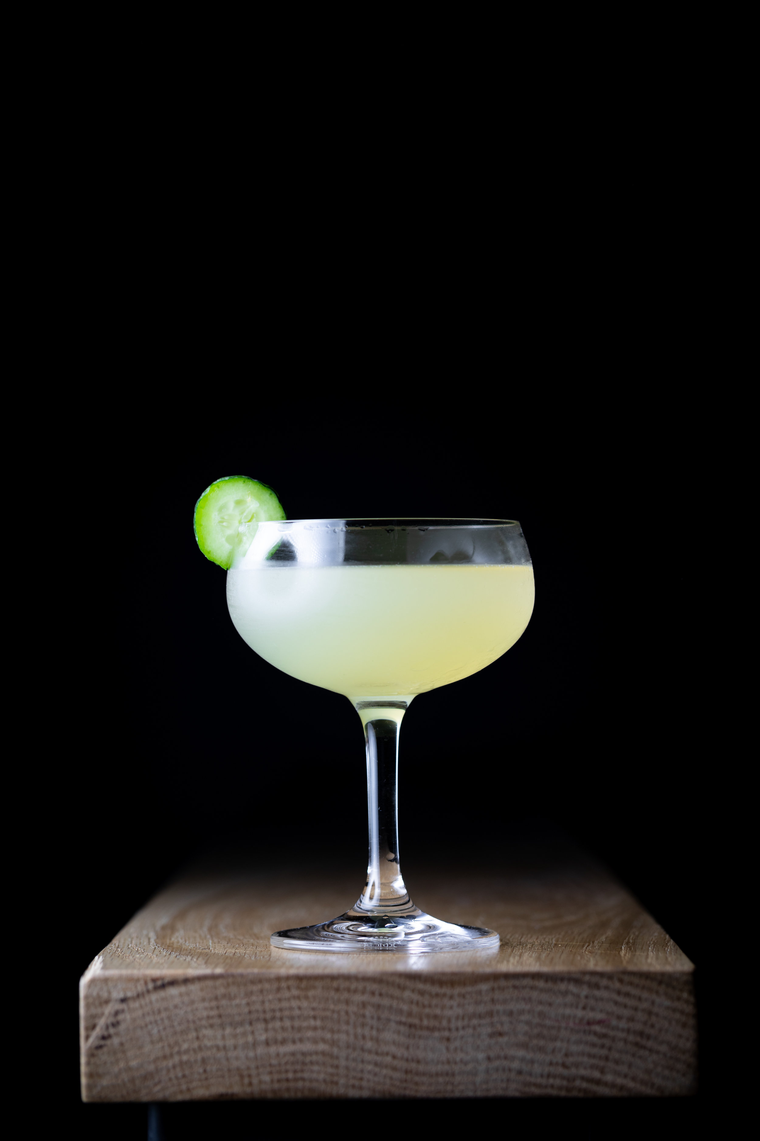 photo of a cocktail garnished with cucumber