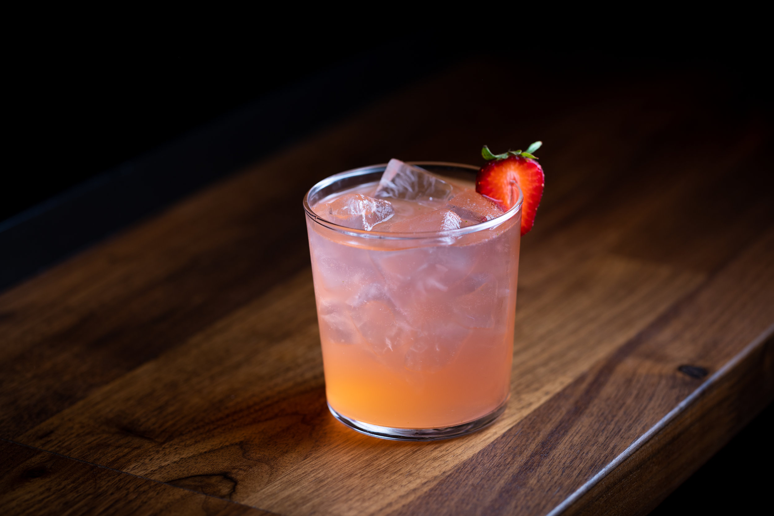 photo of a cocktail garnished with a strawberry