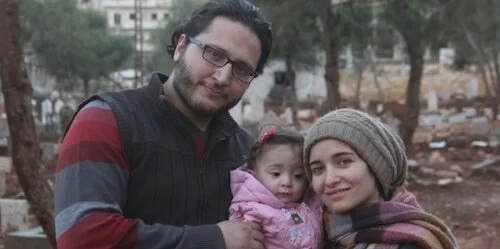 al-Kateab and her family, taking a family portrait in front of a ransacked landscape.