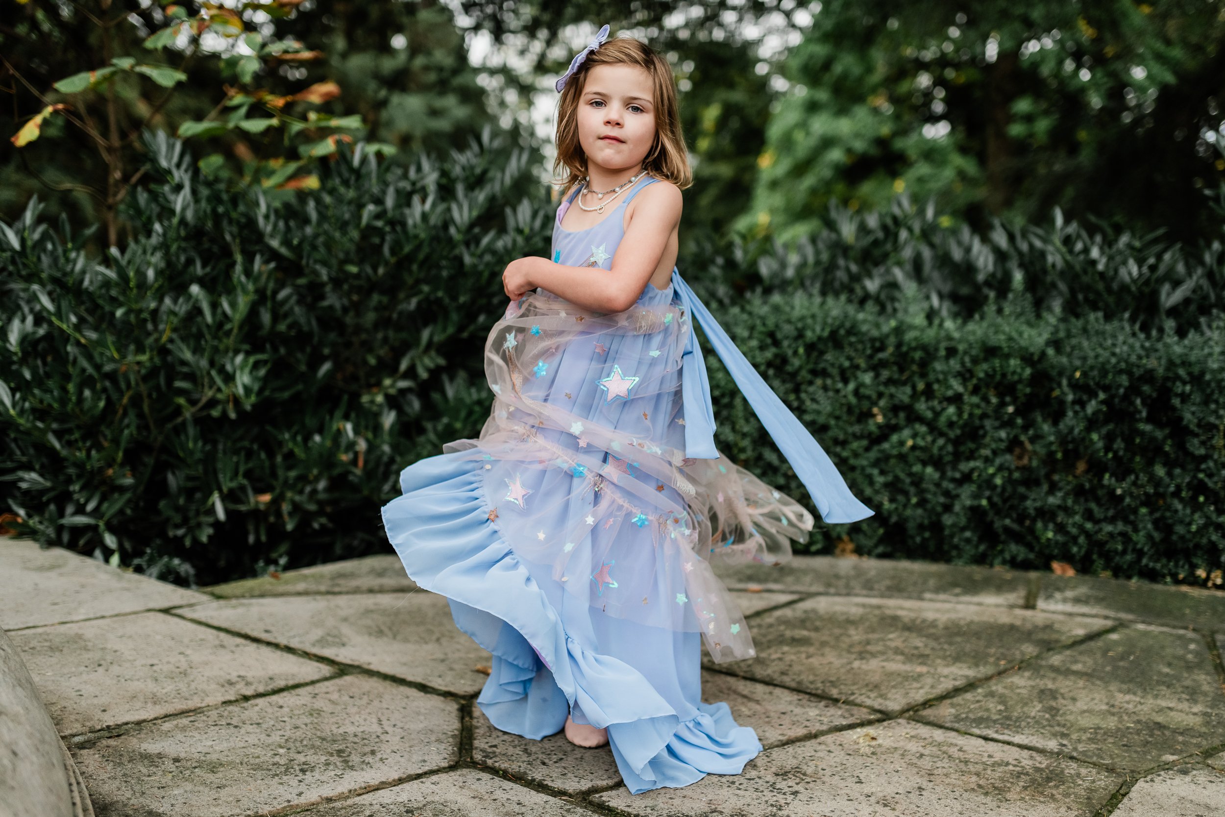  Little girl twirls in her blue princess dress. 