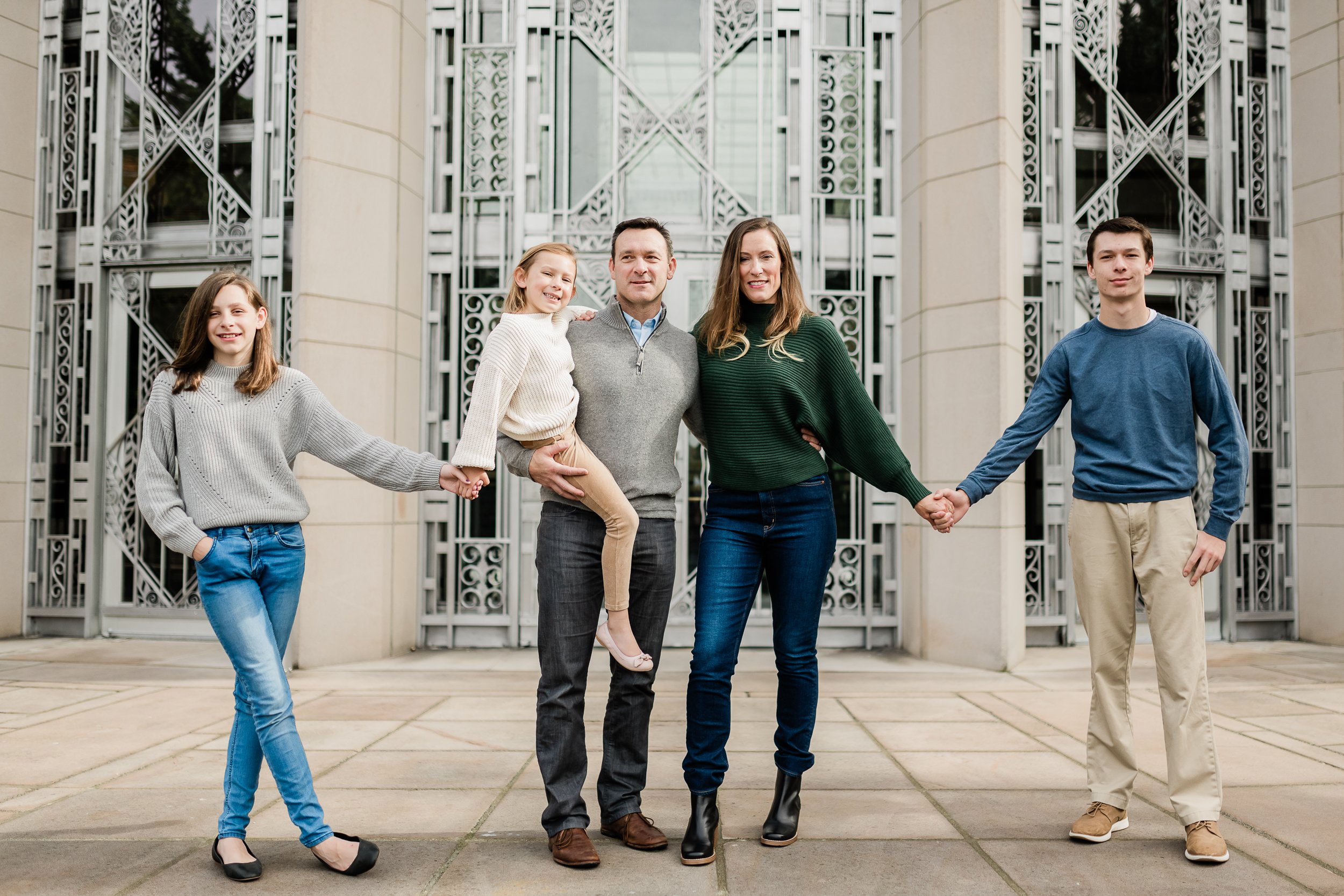  Family of five poses in front of beautiful, ornate doors. 