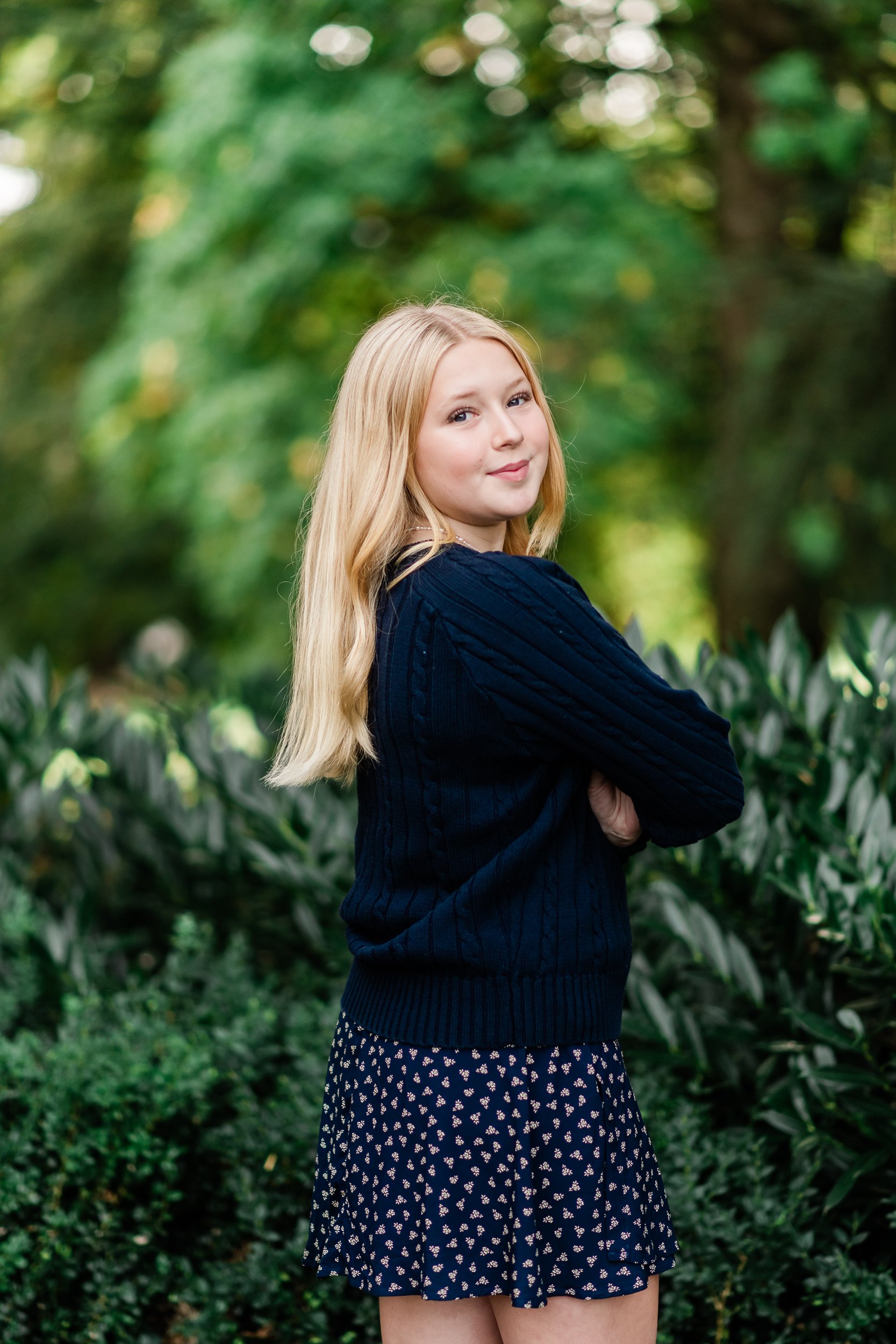  Teenage girl with arms crossed turns to look at the camera. 