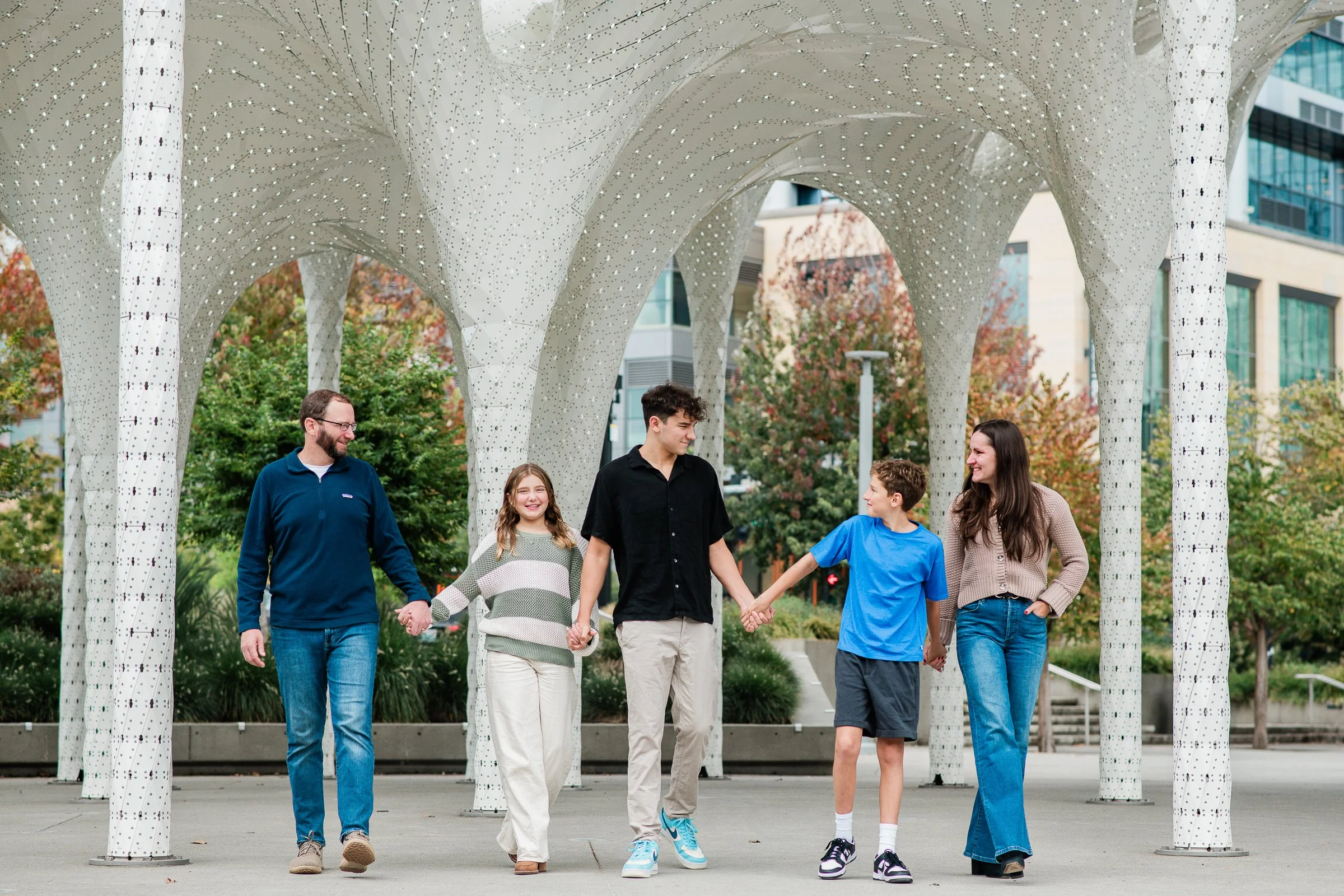 A family of five takes a stroll through Bellevue Downtown Park during a senior portrait session.