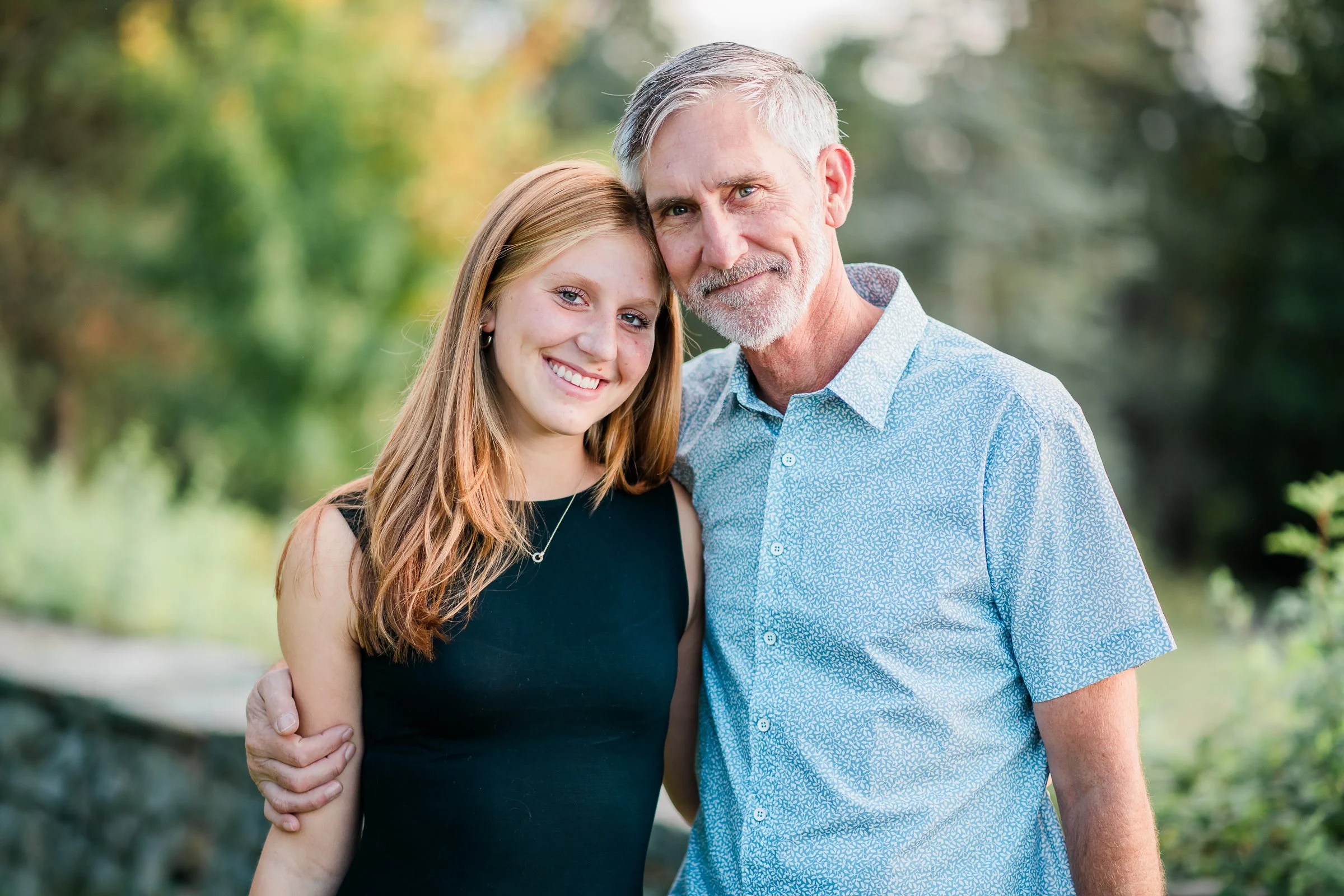 Father and daughter hug during a graduation session at Discovery Park.