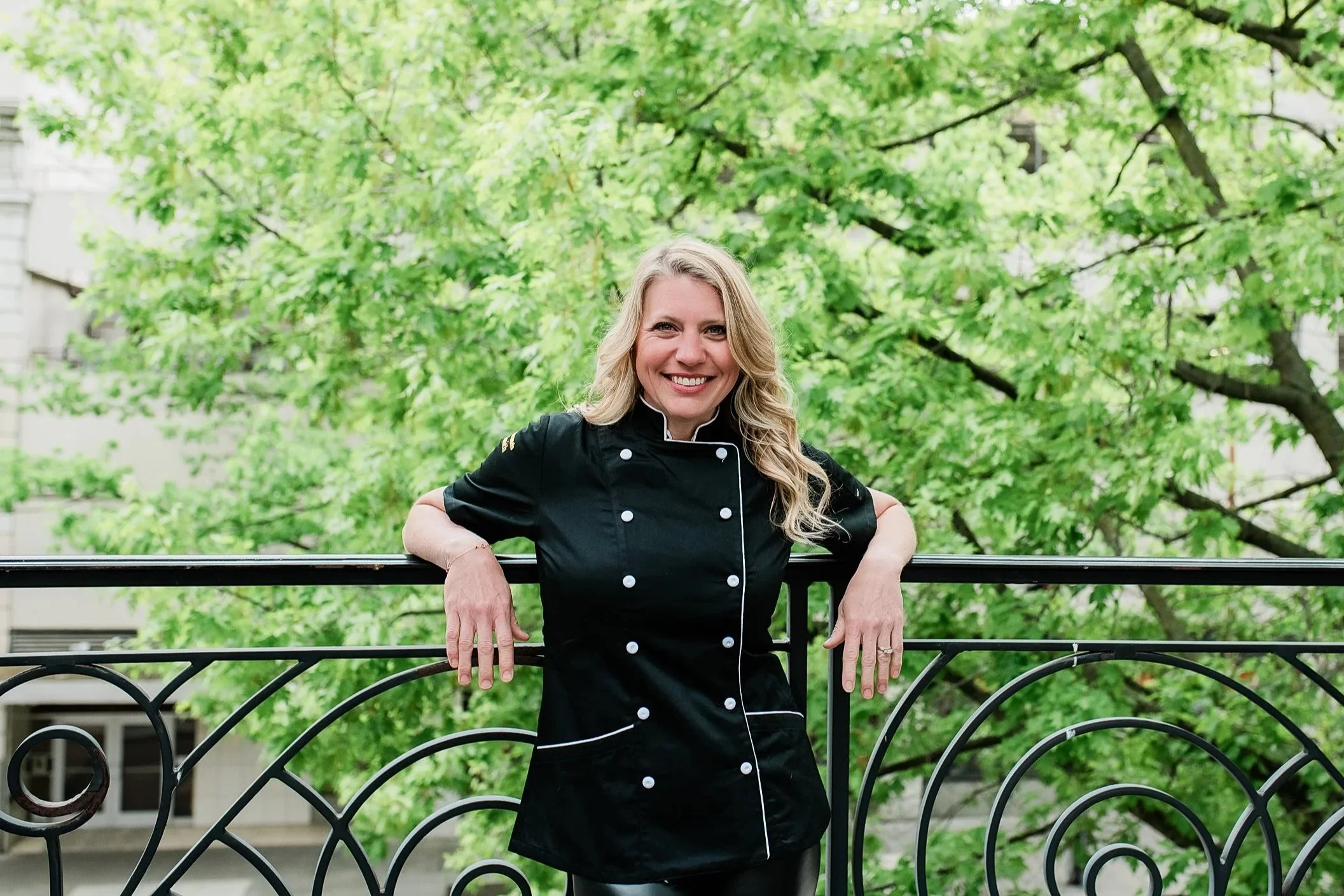 Seattle chocolate maker smiles at camera while on a balcony in downtown Seattle