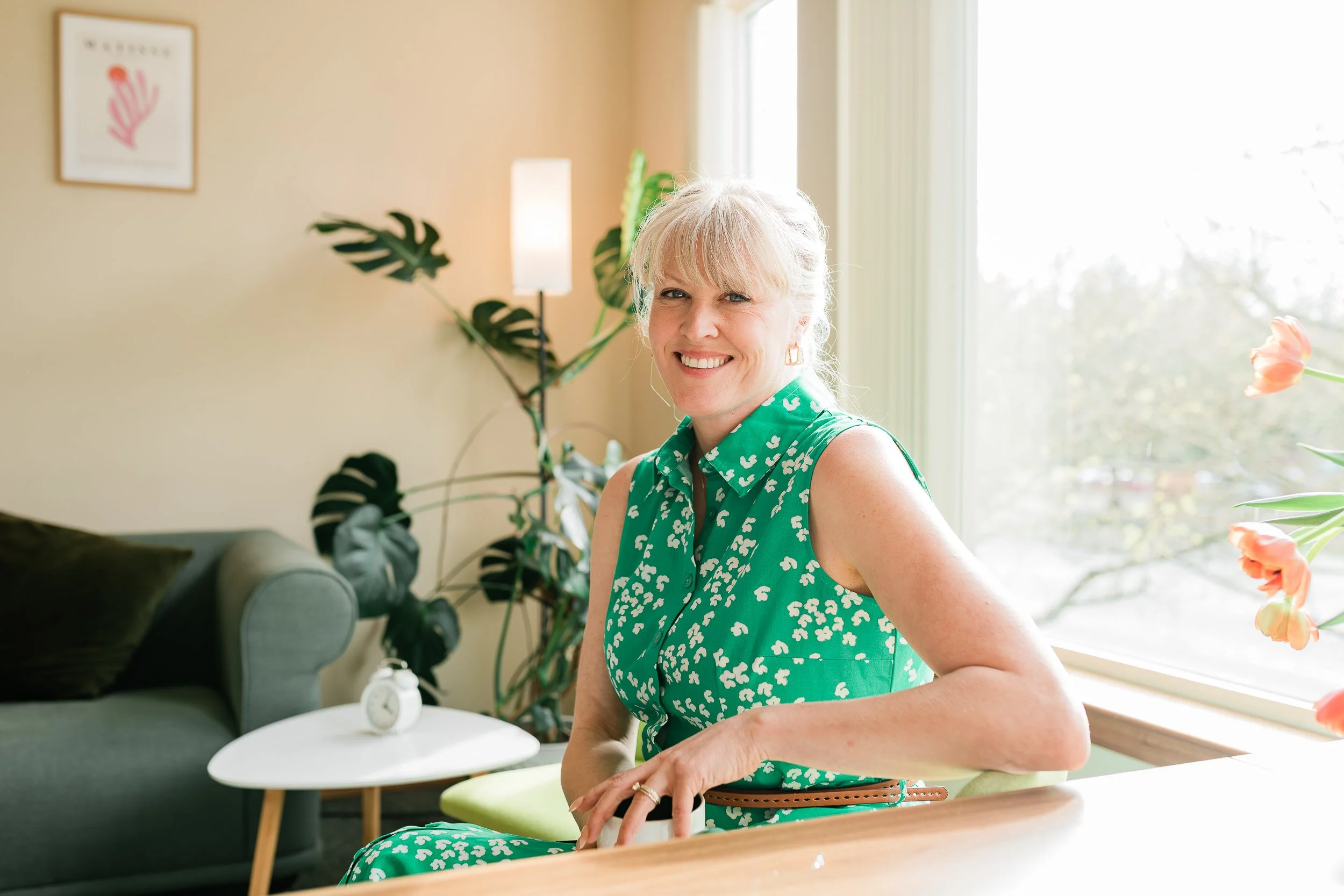 female business owner smiles at the camera in her Everett office