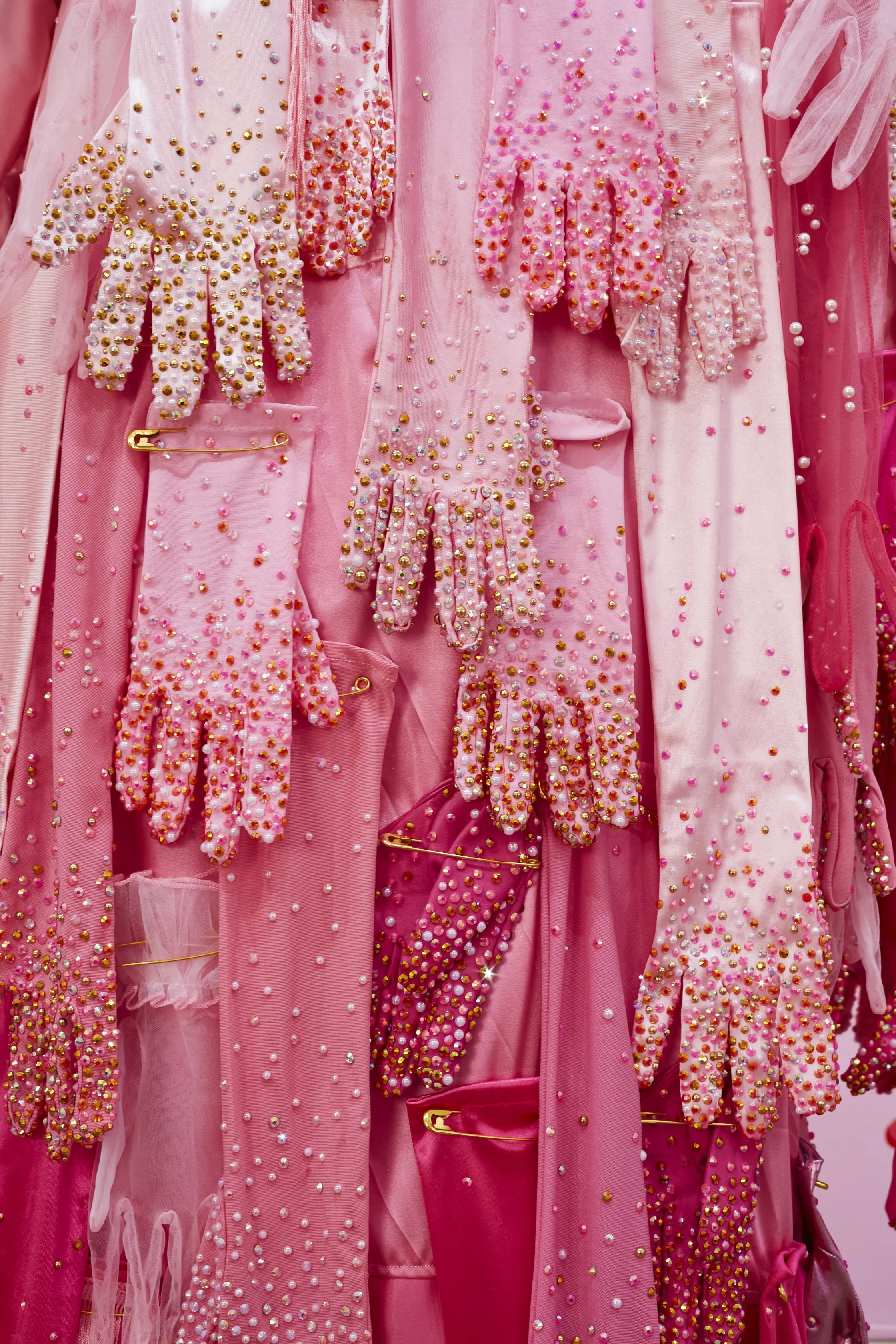   Hands Off!  (detail), 2025. Performative garment made from fabric, gloves, rhinestones, fringe, faux pearls, and oversized safety pins. 