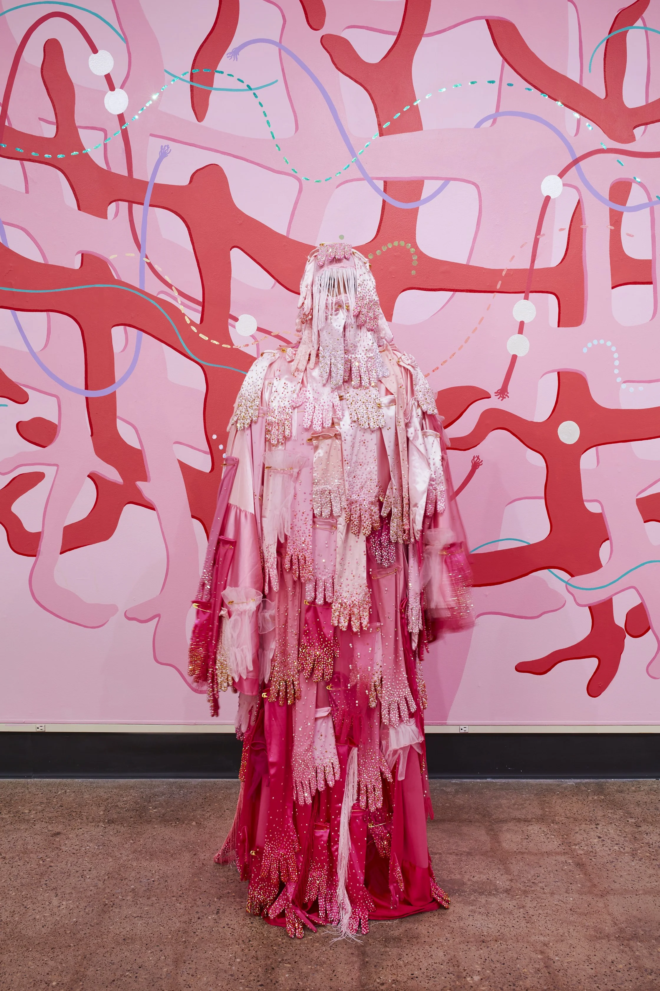   Hands Off! , 2025. Performative garment made from fabric, gloves, rhinestones, fringe, faux pearls, and oversized safety pins. 