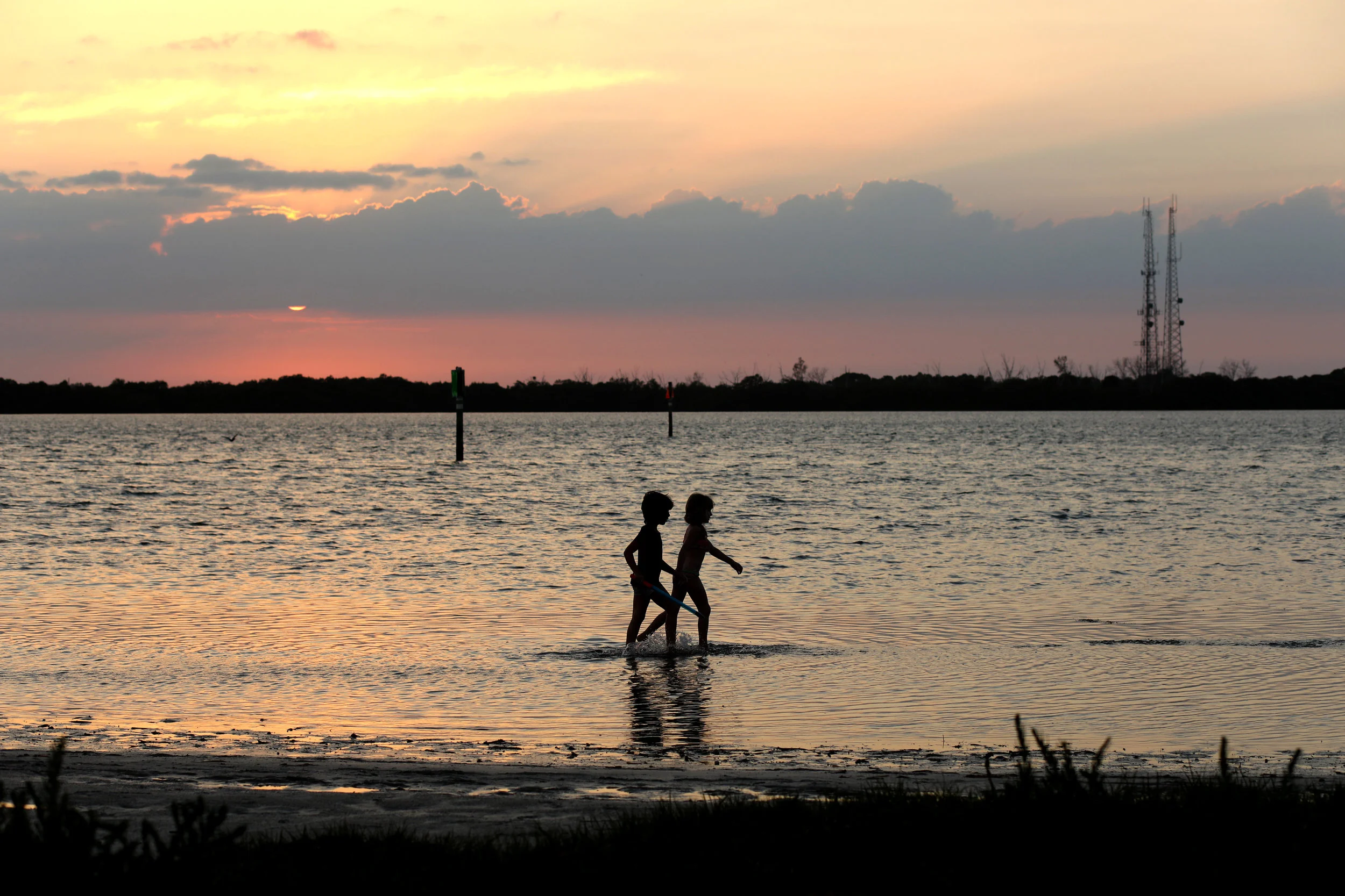   Get the Vacation You’ve Been Craving on a Budget: Go Camping   Young campers play in the water at sunset at the Fort De Soto campgrounds in Florida. 