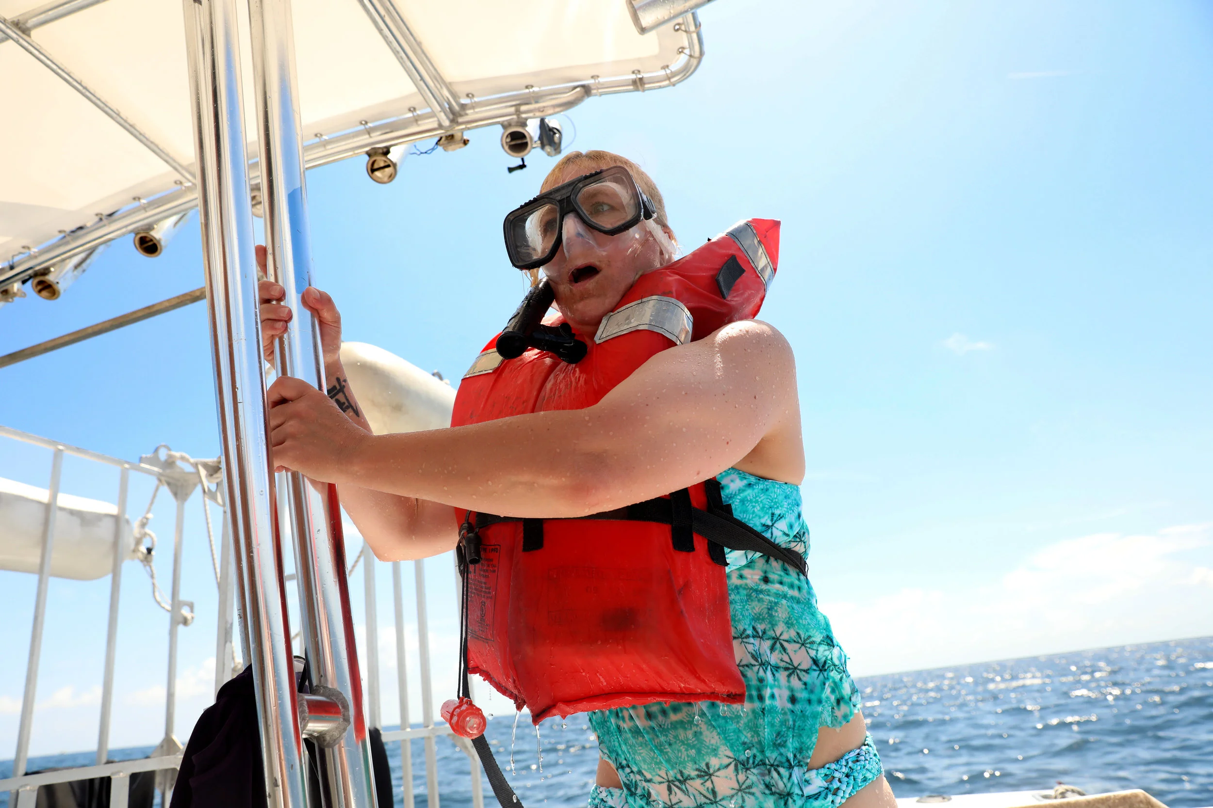  A guest climbs back aboard after an up-close encounter swimming with sharks. 