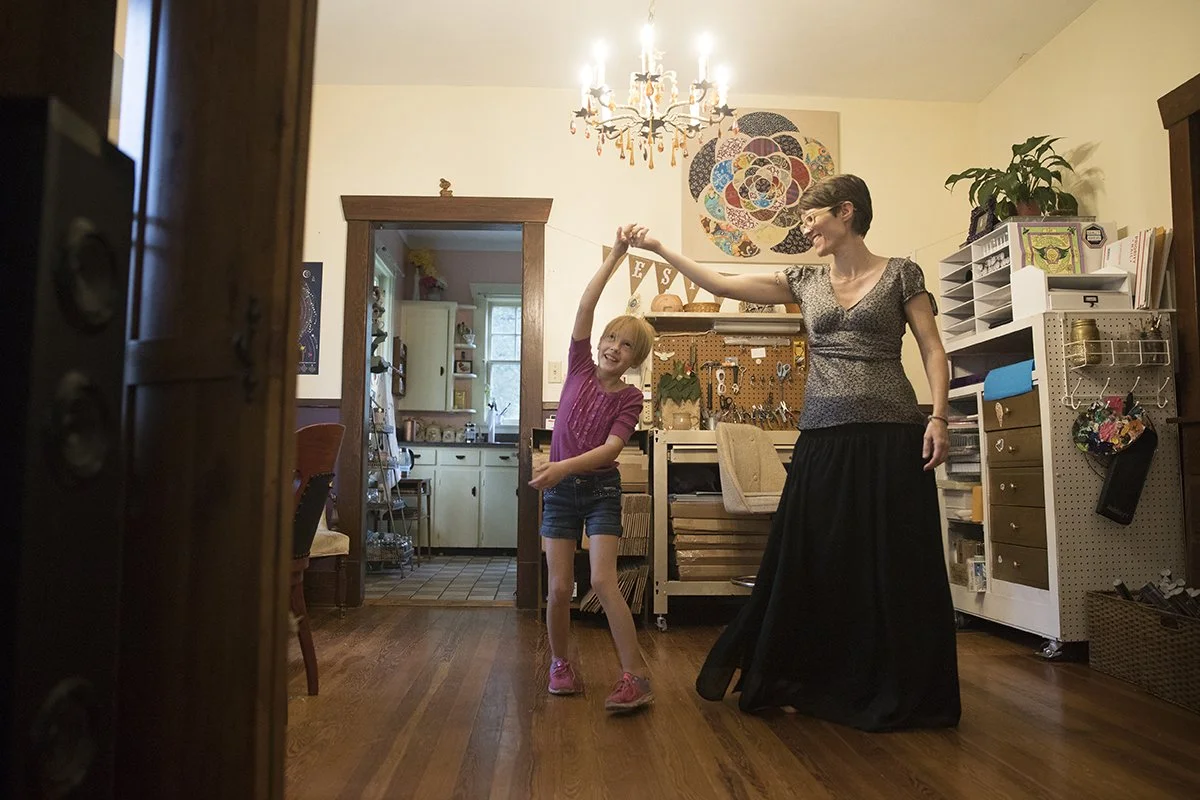  Maya Wilder and Julie Wilder dance to music inside their home after packaging up sold Spectrum Cosmic Calendars.  