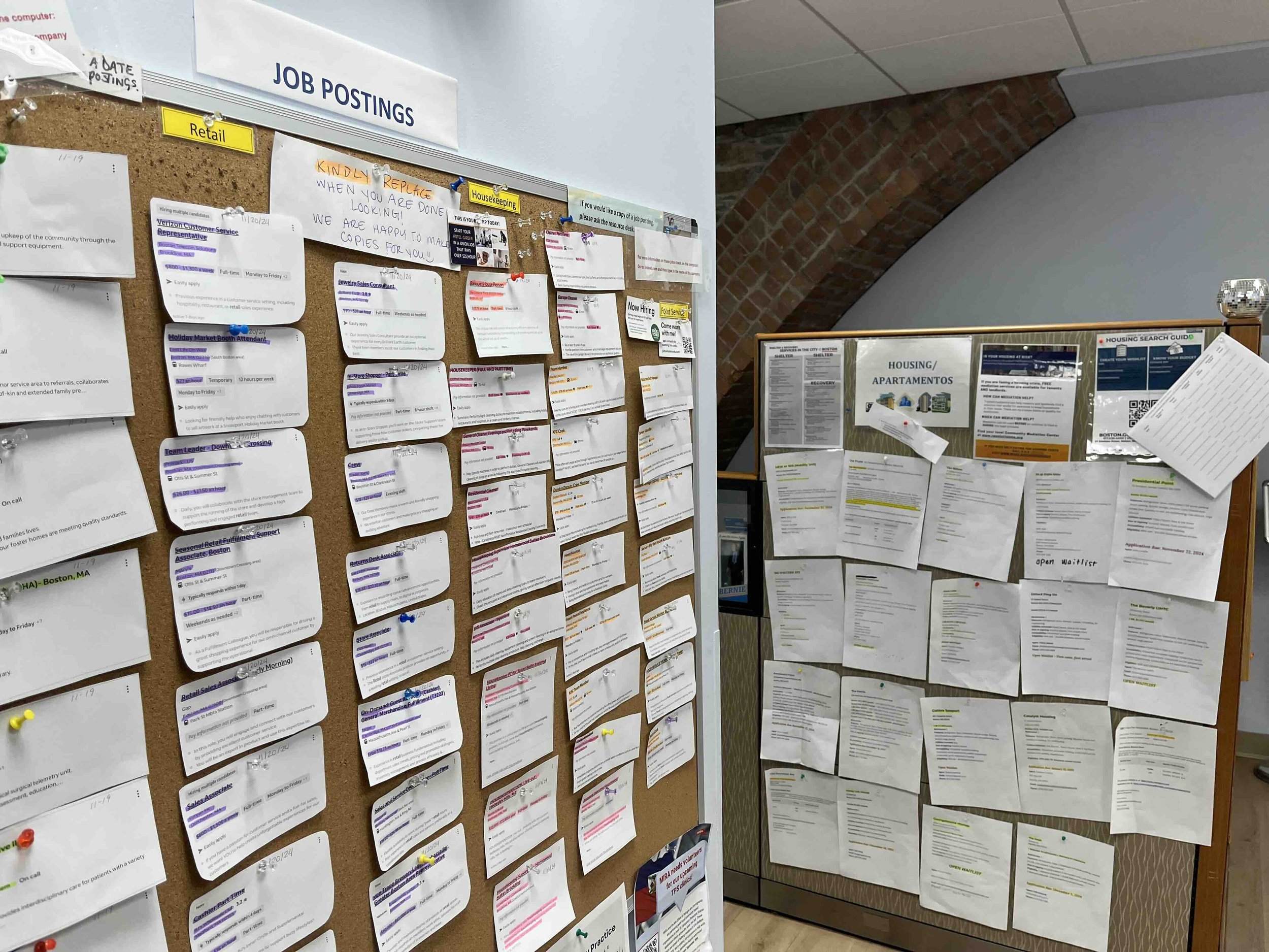 A job board at women's lunch place with paper postings that have important details highlighted.