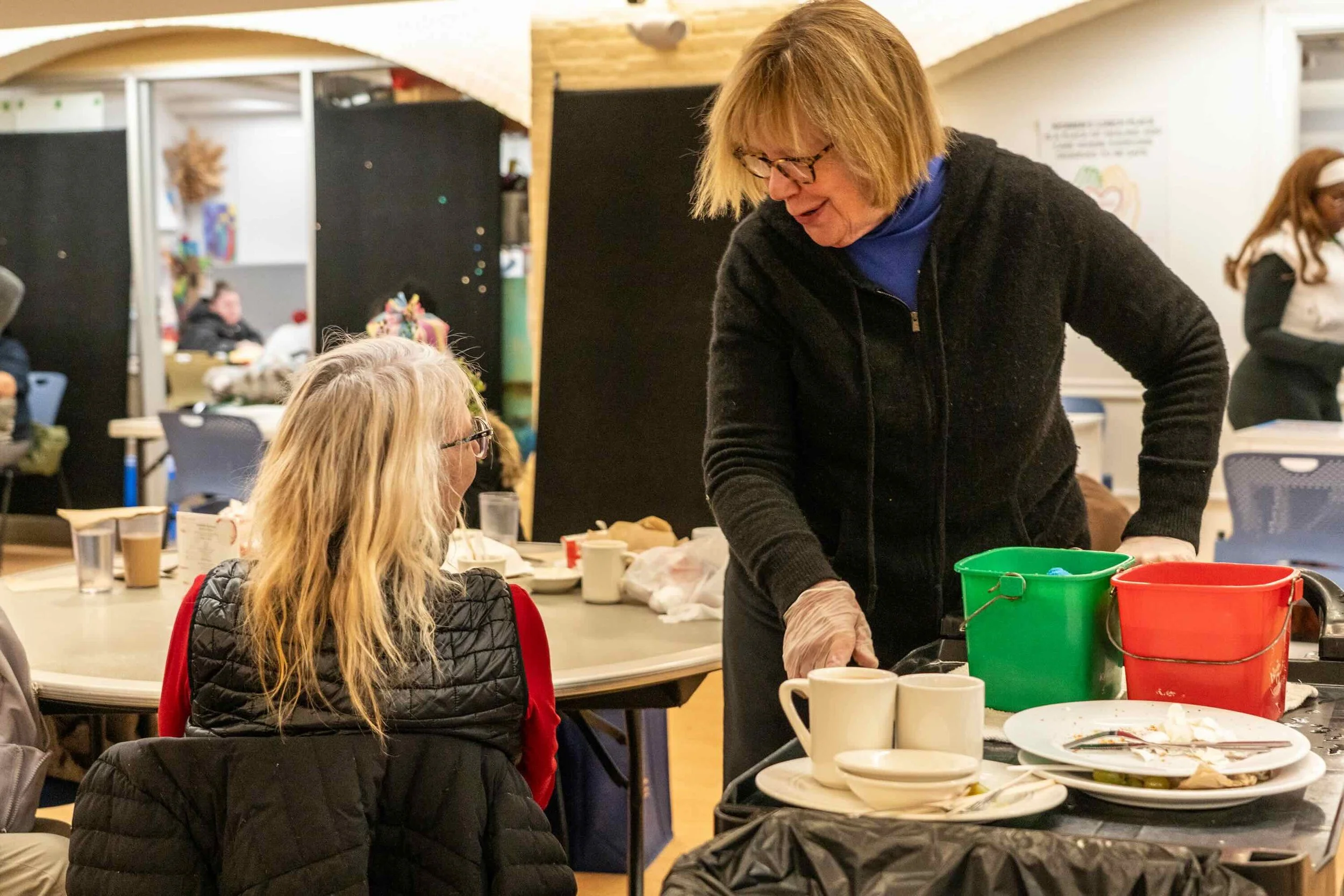 A volunteer has a warm conversation with a guest in our community dining area.