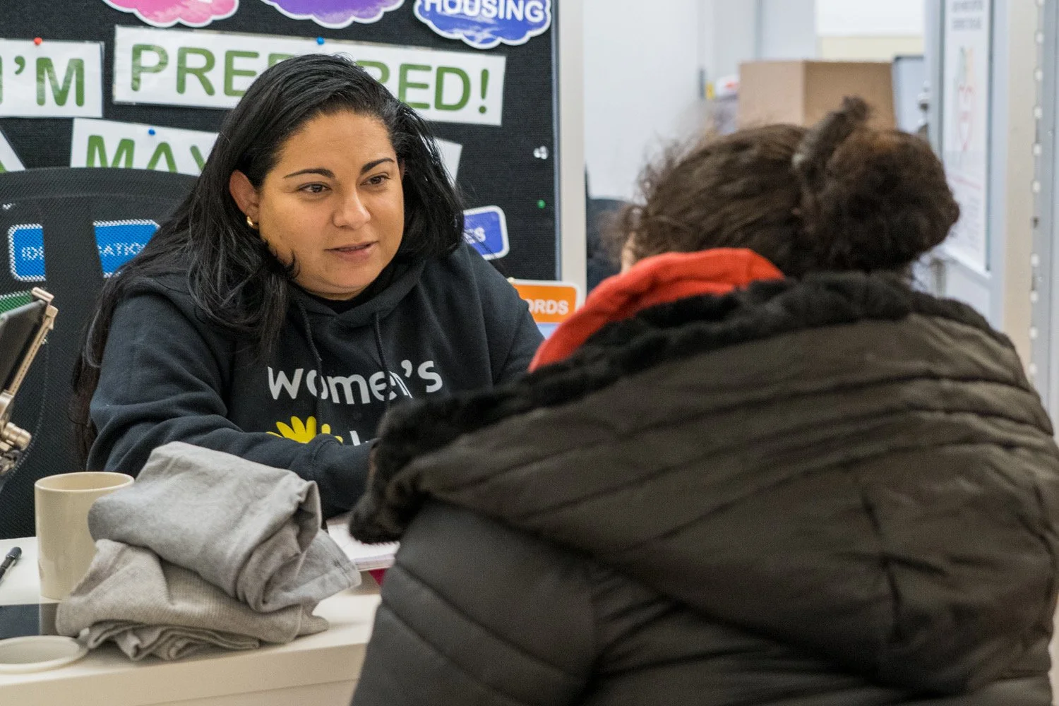 A case manager listens intently to a guest at Women's Lunch Place.