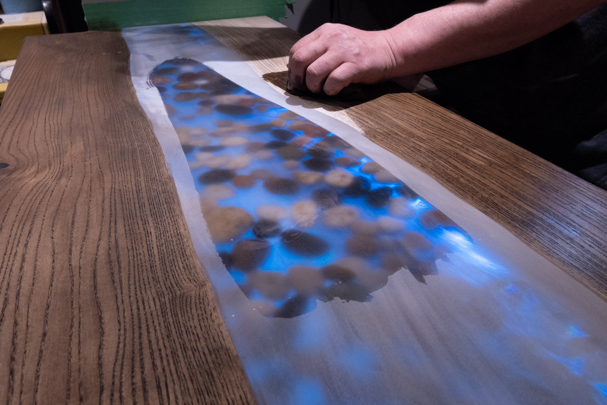 Putting the finishing touches on a custom epoxy bar top in a basement renovation in Acton