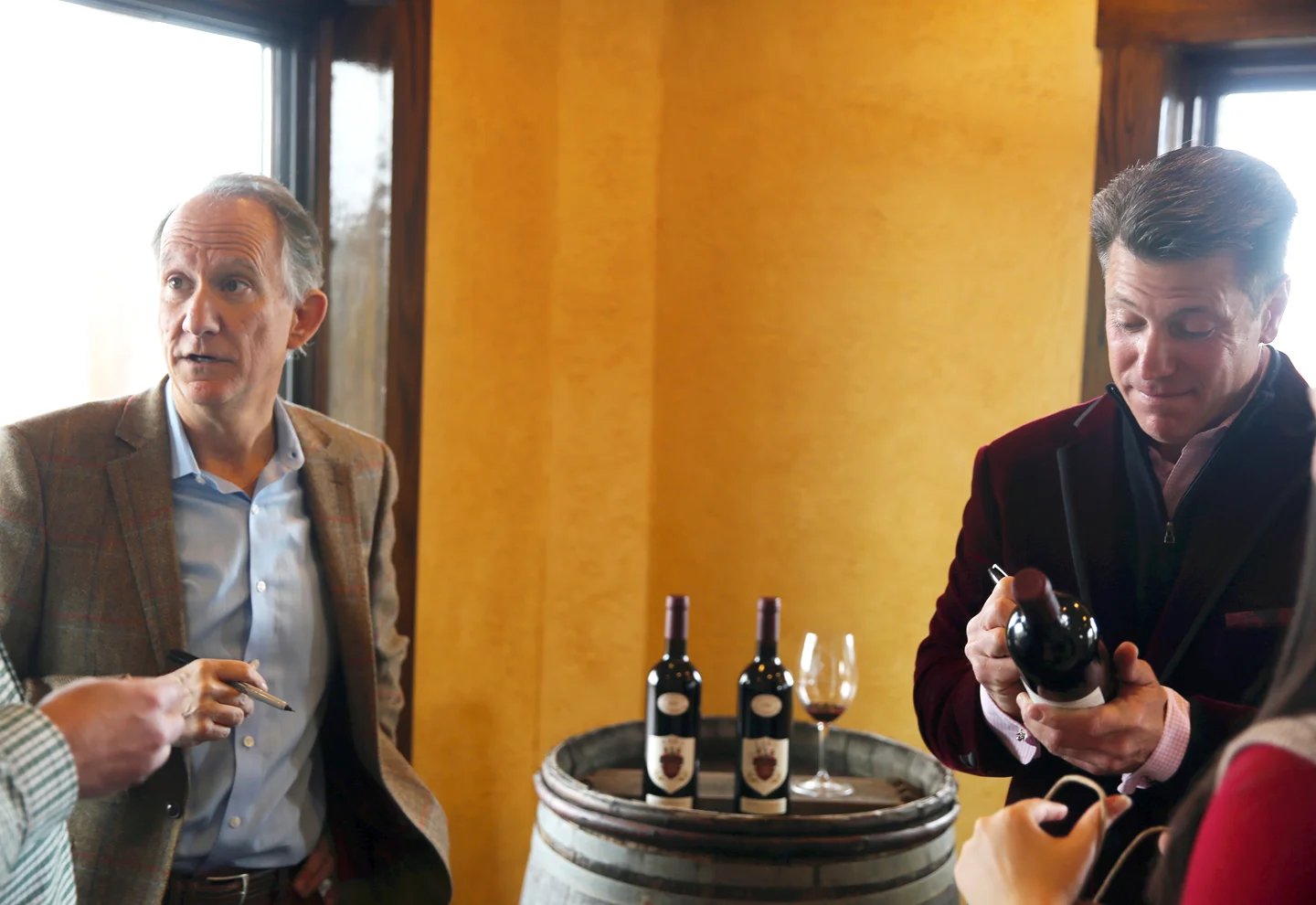 Jay Raffaldini (left) and JW Ray (right) sign bottles of their collaboration wine, Sisboombah.