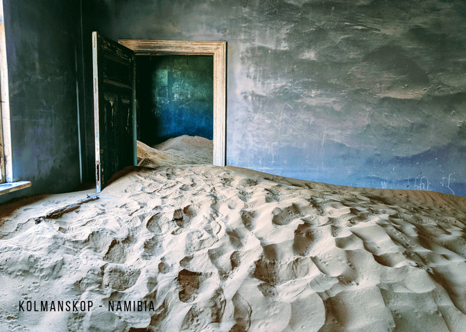Waves of sand overwhelm an abandoned house in Kolmanskop, Namibia