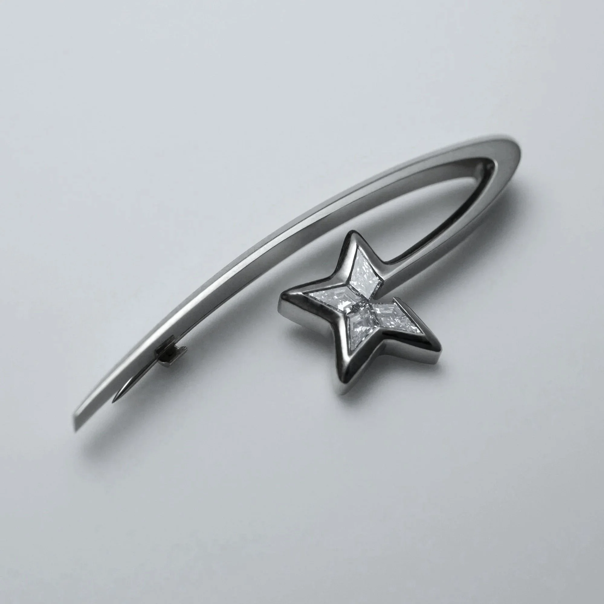 White gold brooch with lab kite diamonds in the form of a shooting star, handmade by goldsmith Julia Bocanet in Amsterdam.