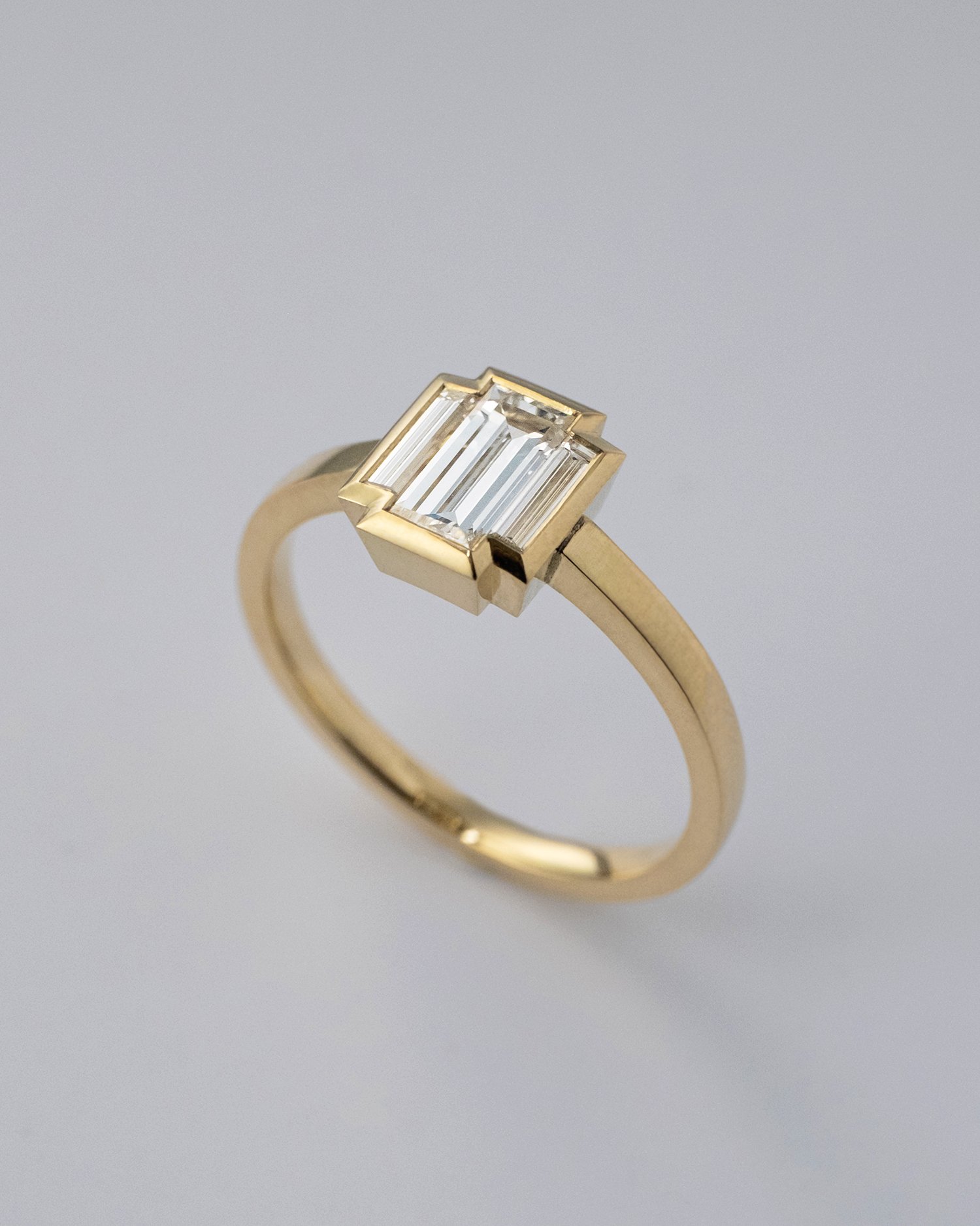 Custom made gold engagement ring with baguette diamonds, inspired by art deco style, made by a goldsmith in Amsterdam.